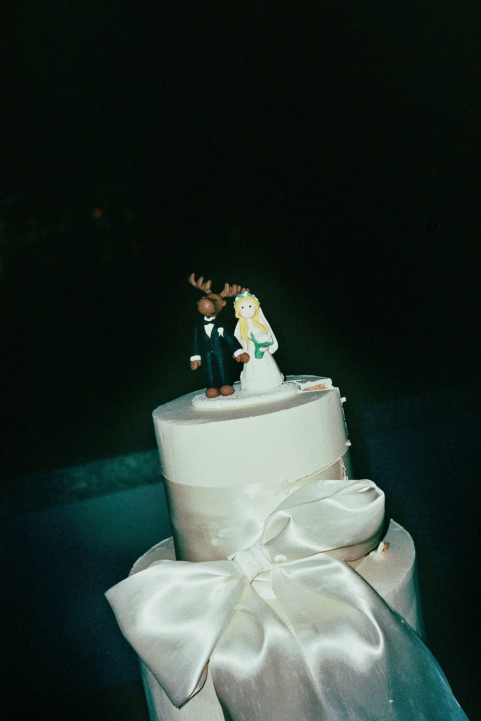 Sleek editorial-style wedding cake with sculptural bow – cinematic reception detail by Studio Aelina