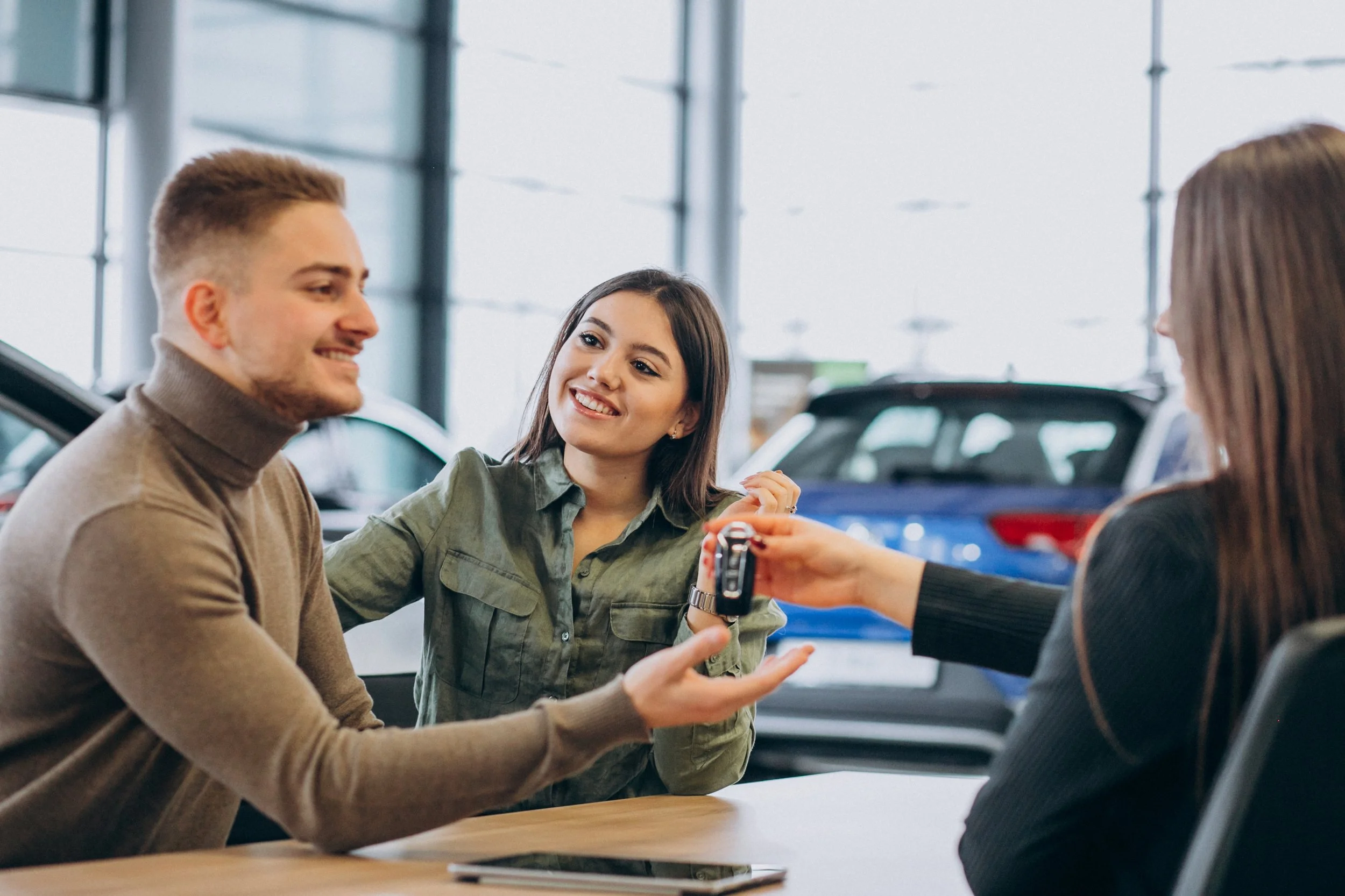 Young couple purchasing car in showroom