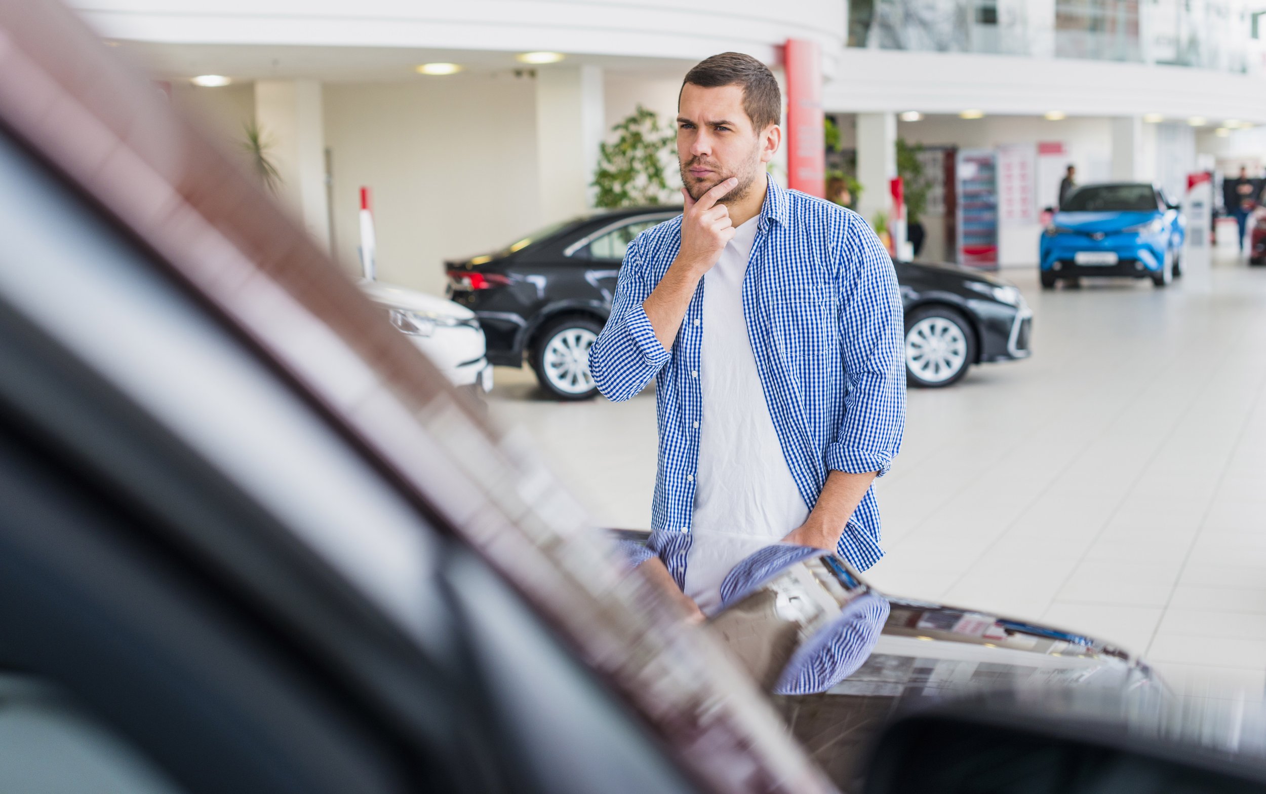 Man checking out new vehicles in car showroom