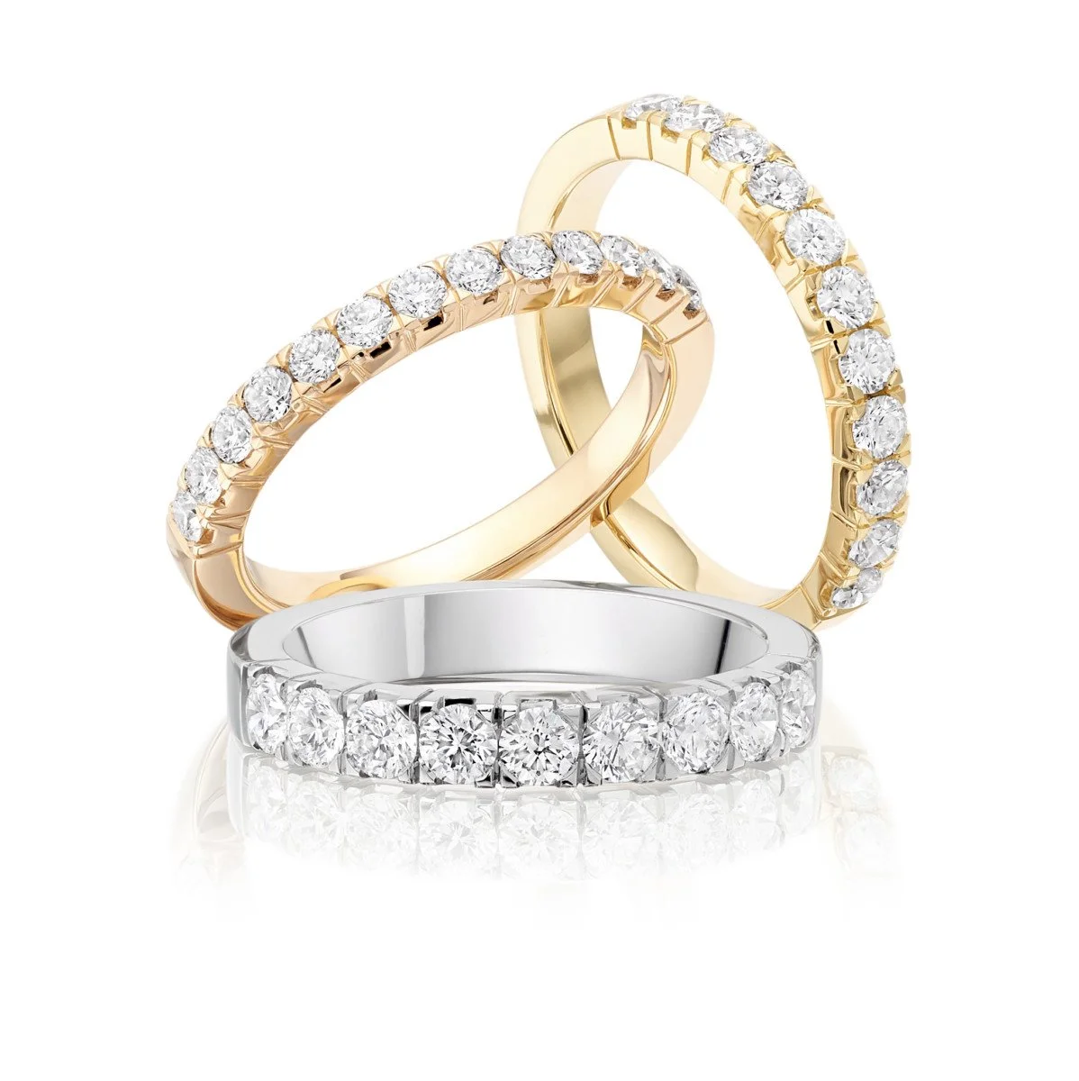 Three diamond wedding bands, two gold and one silver, with diamonds set around the bands.