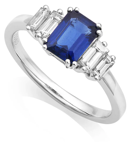 A silver ring featuring a large rectangular blue gemstone flanked by two smaller rectangular clear stones on each side.