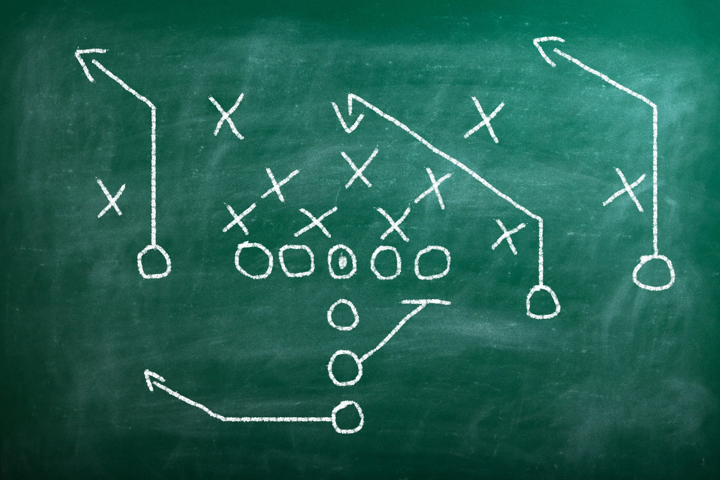 Taktische Skizze eines American Football Spielzugs auf einer Tafel gezeichnet.