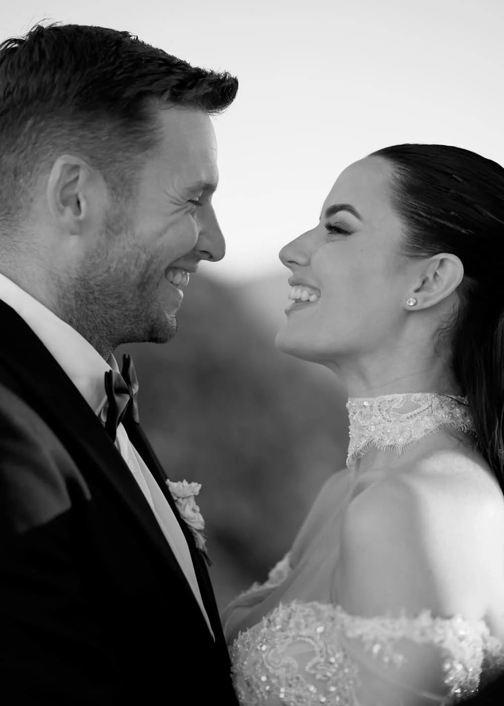 A black-and-white photo of a happy couple smiling at each other, dressed in Son Marroig