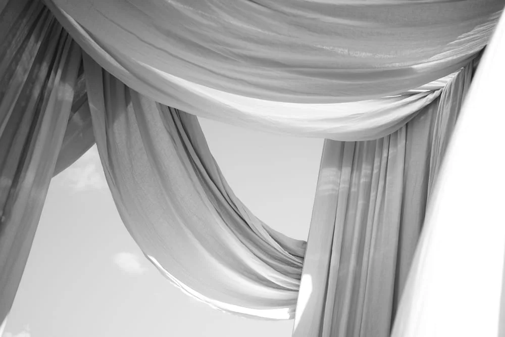 Close-up of flowing, draped curtains in black and white.