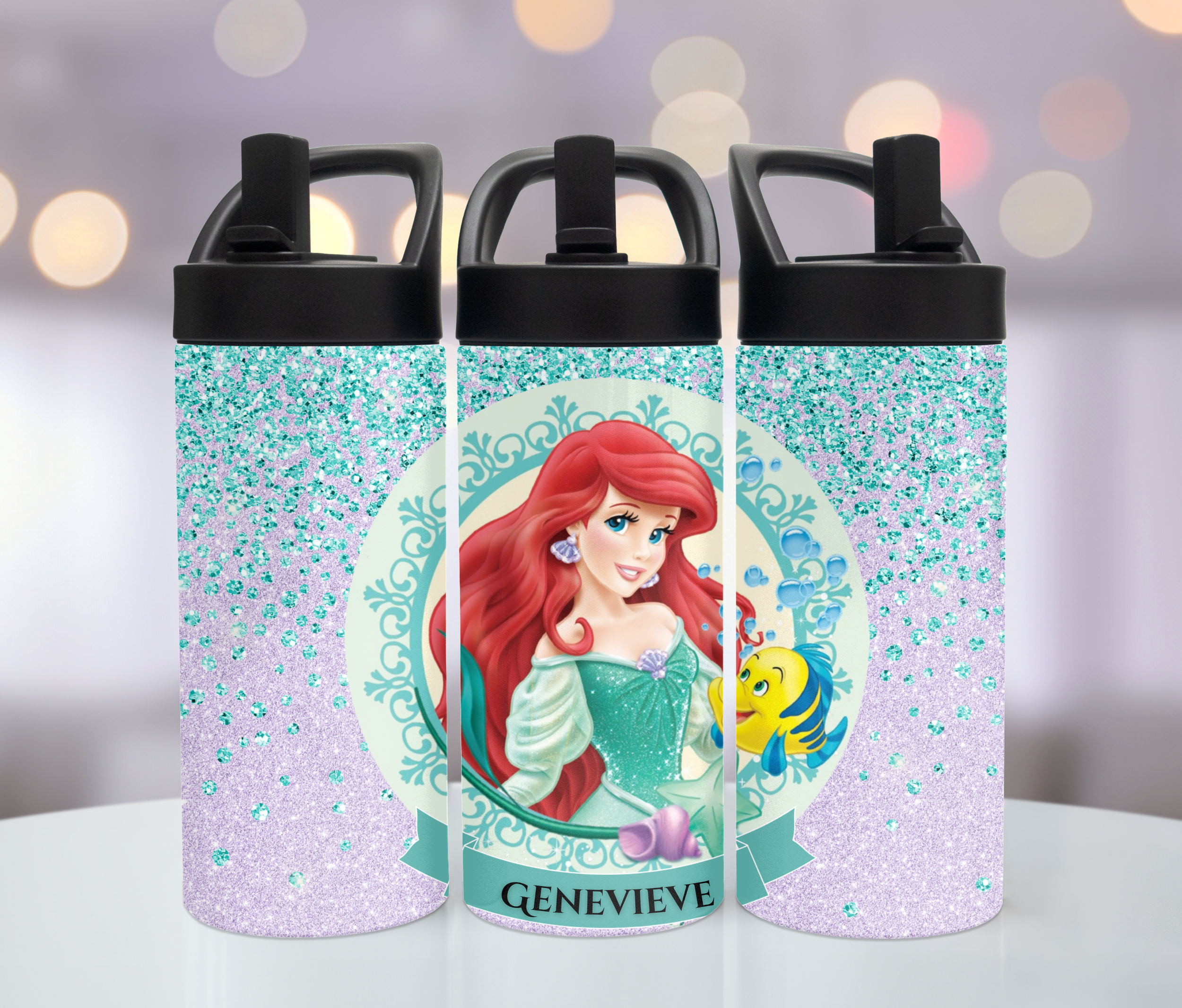 Three water bottles with a Disney Ariel and Flounder design, personalized with the name Genevieve, on a blurred background with bokeh lights.