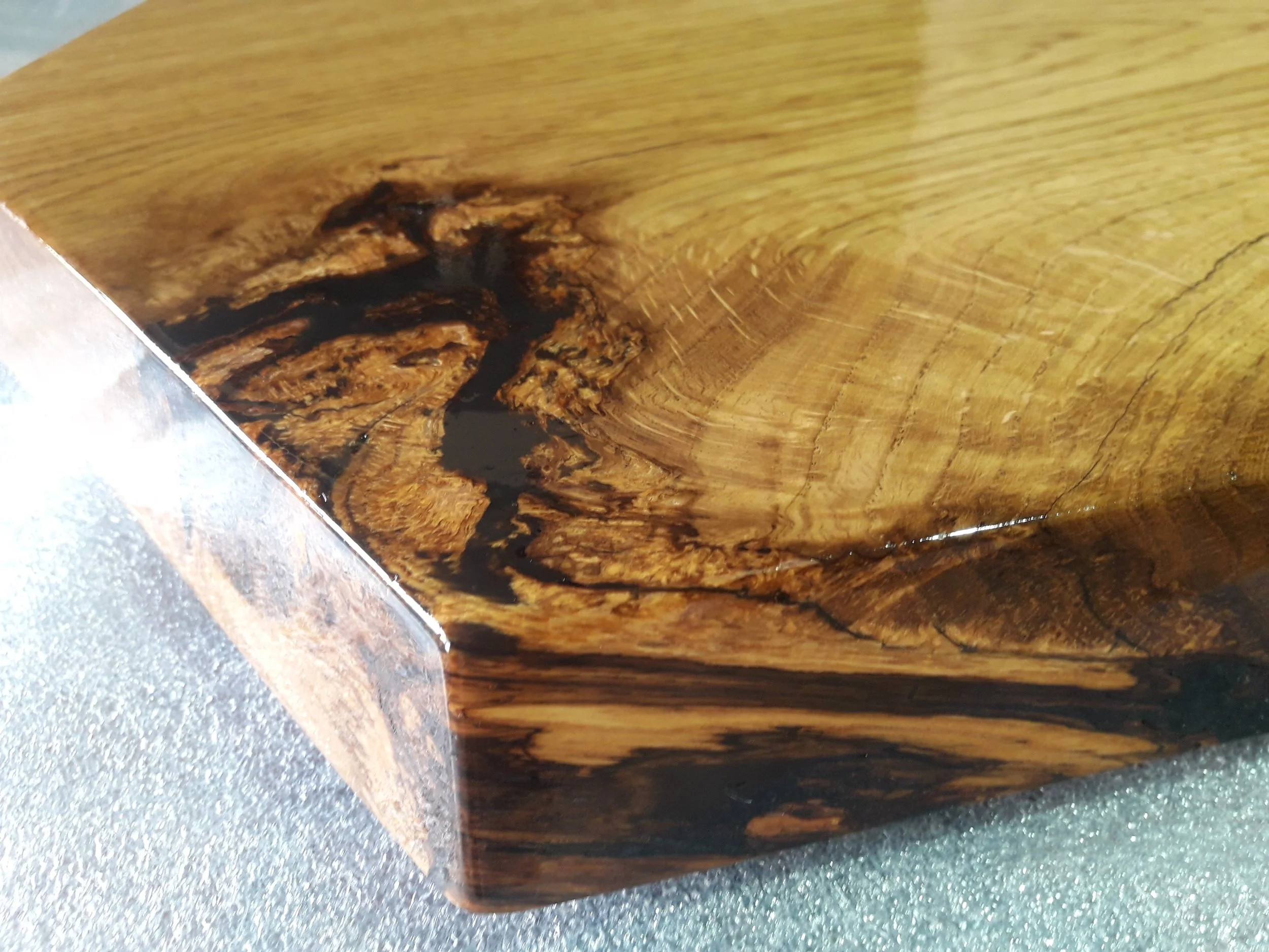 Close-up of a polished wooden surface with dark natural grain patterns.