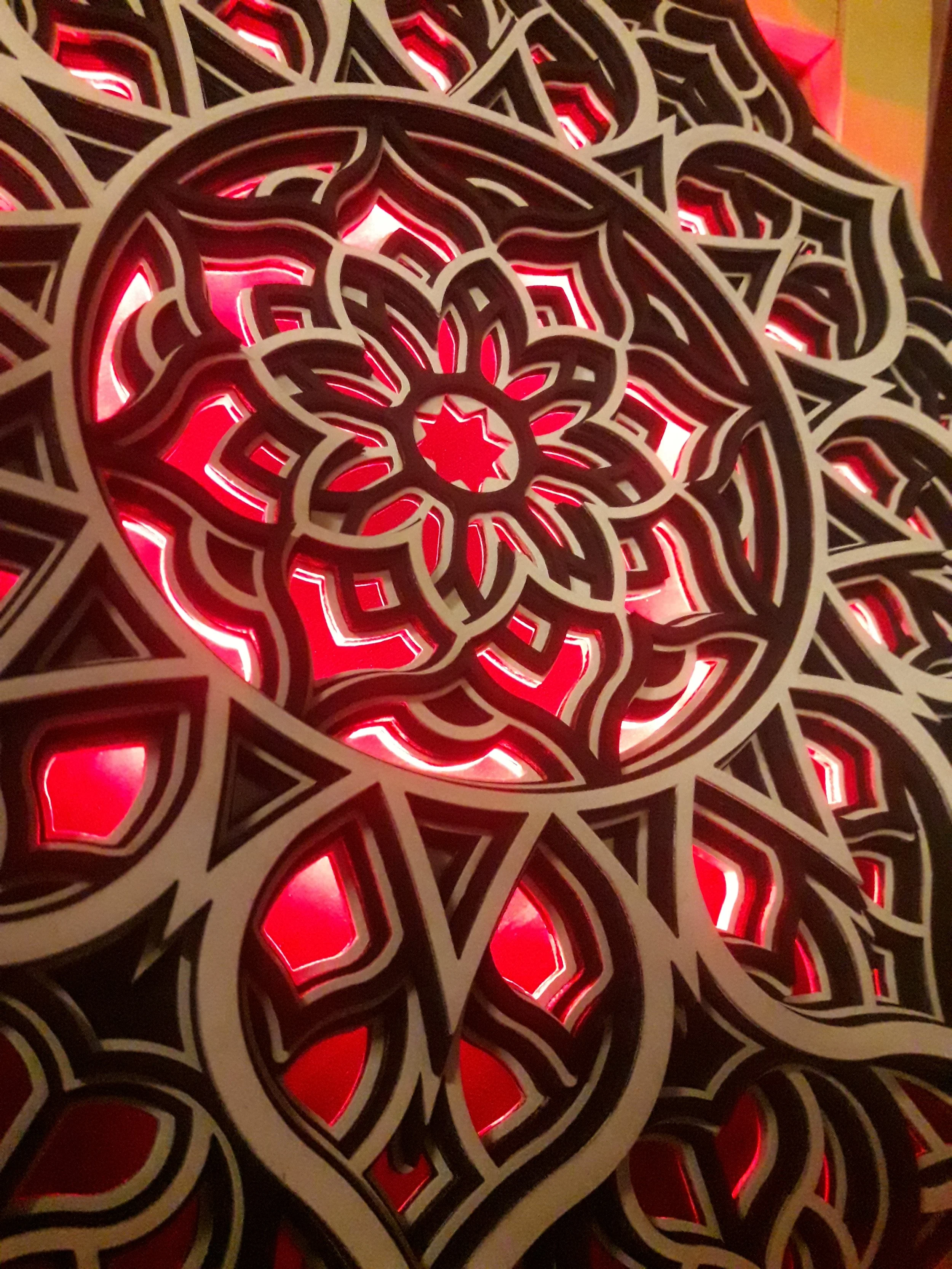 Intricate mandala design with red backlighting.