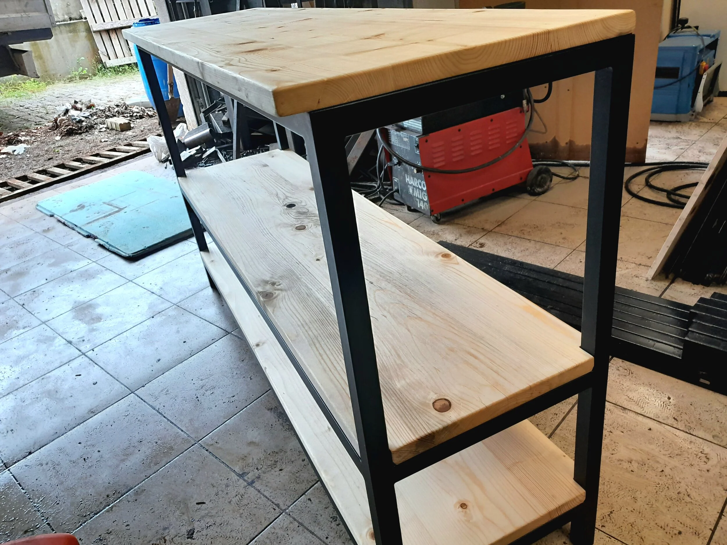 Wooden shelving unit with metal frame in a workshop