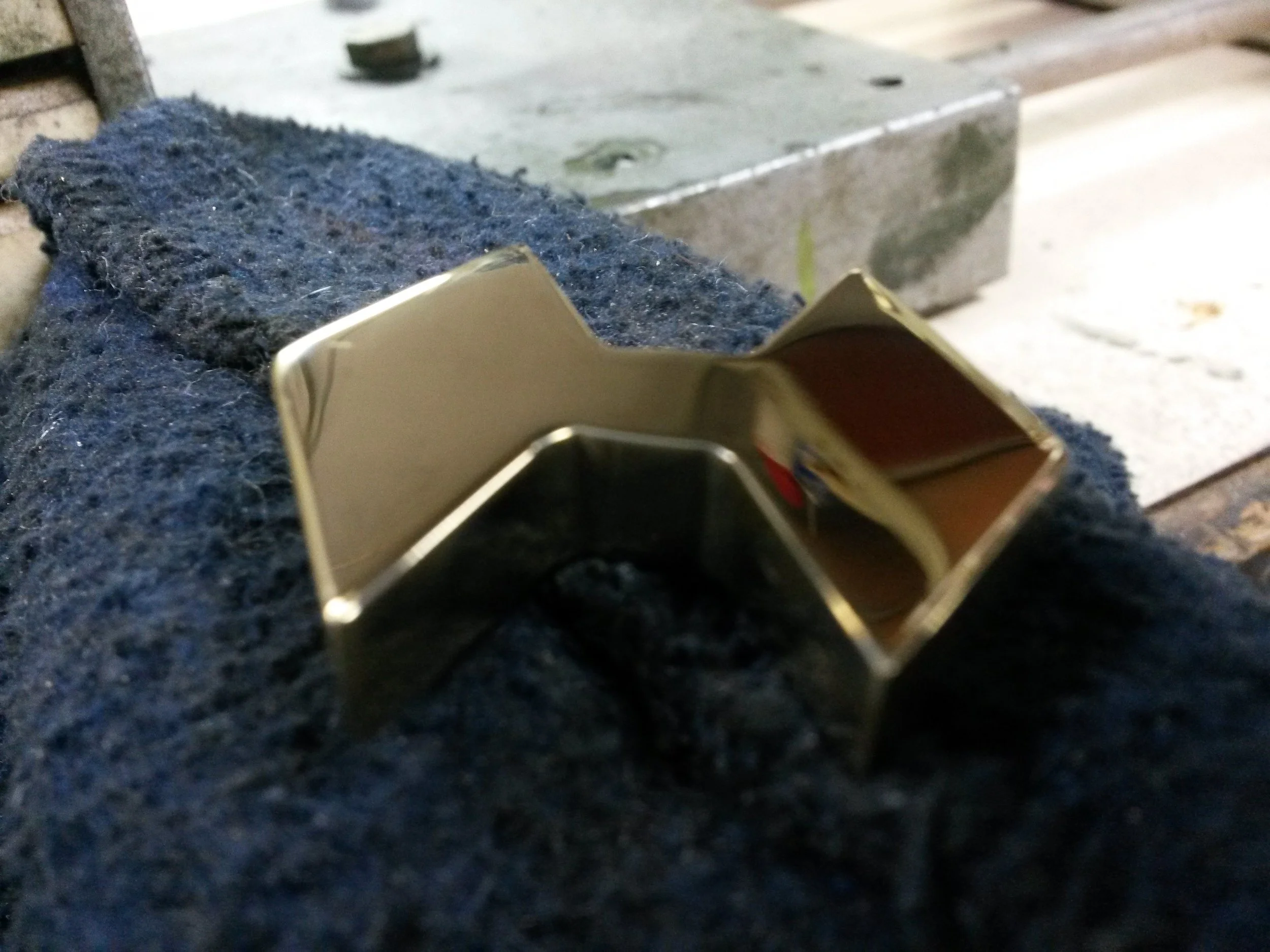 Polished metal object on a textured fabric surface.