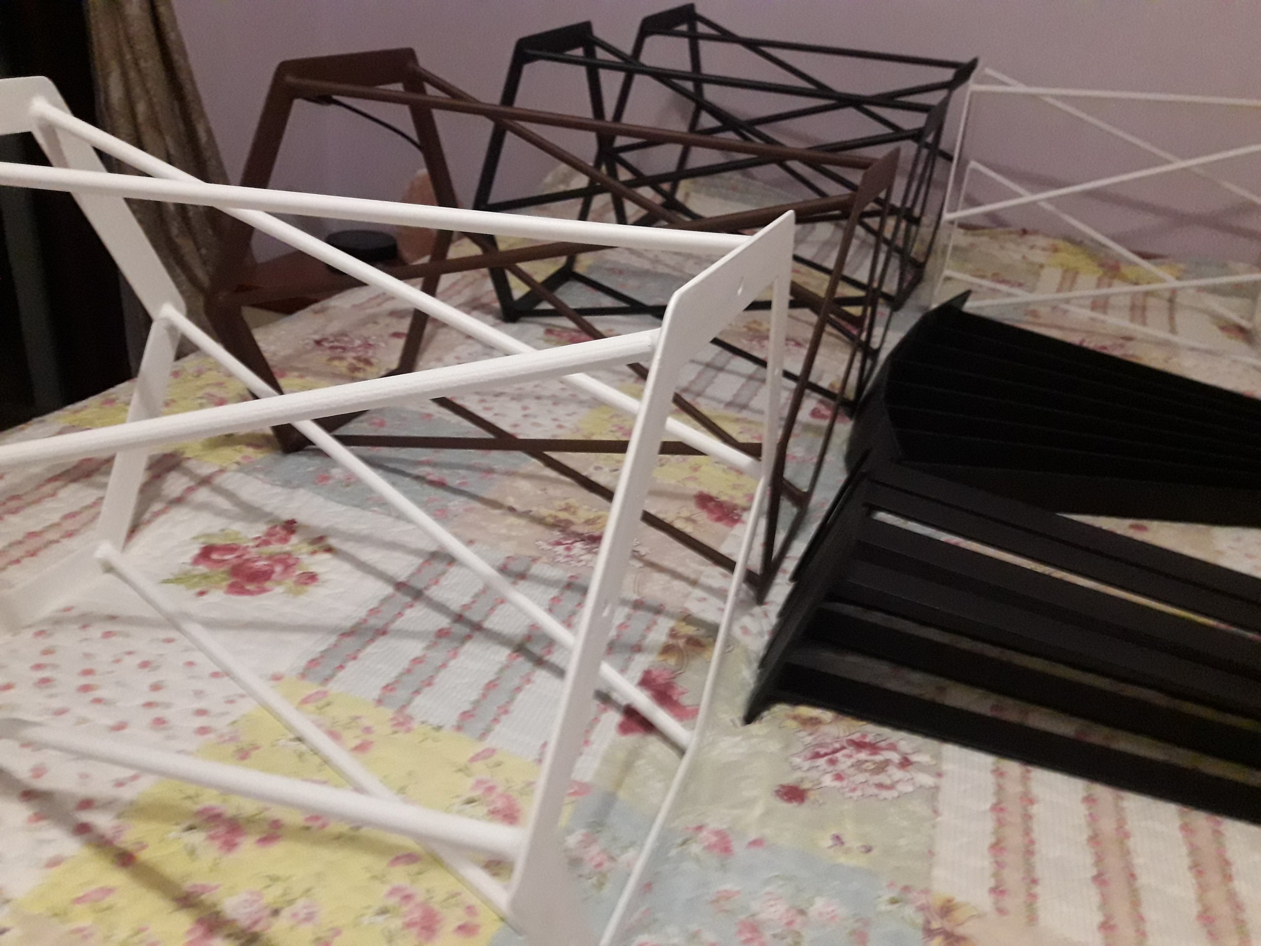 Collapsible racks of various colors on a floral bedspread