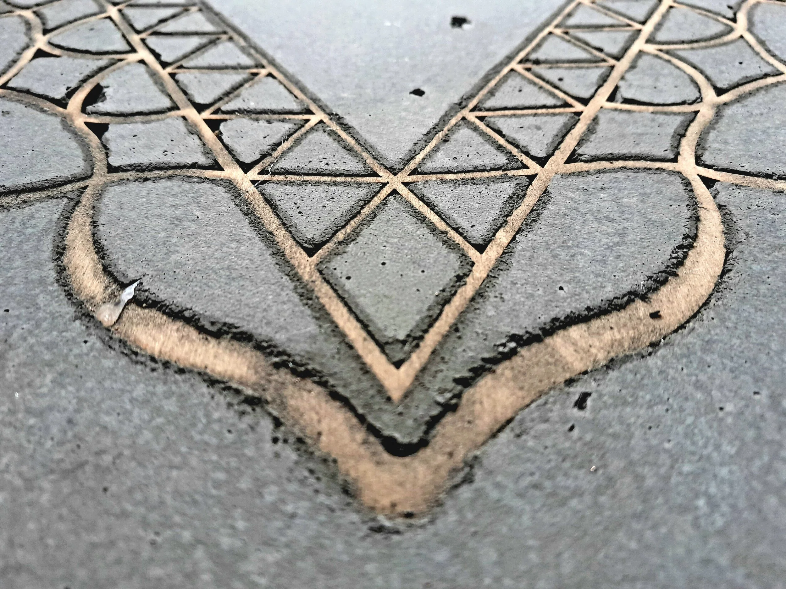 Close-up of geometric pattern engraved in concrete.