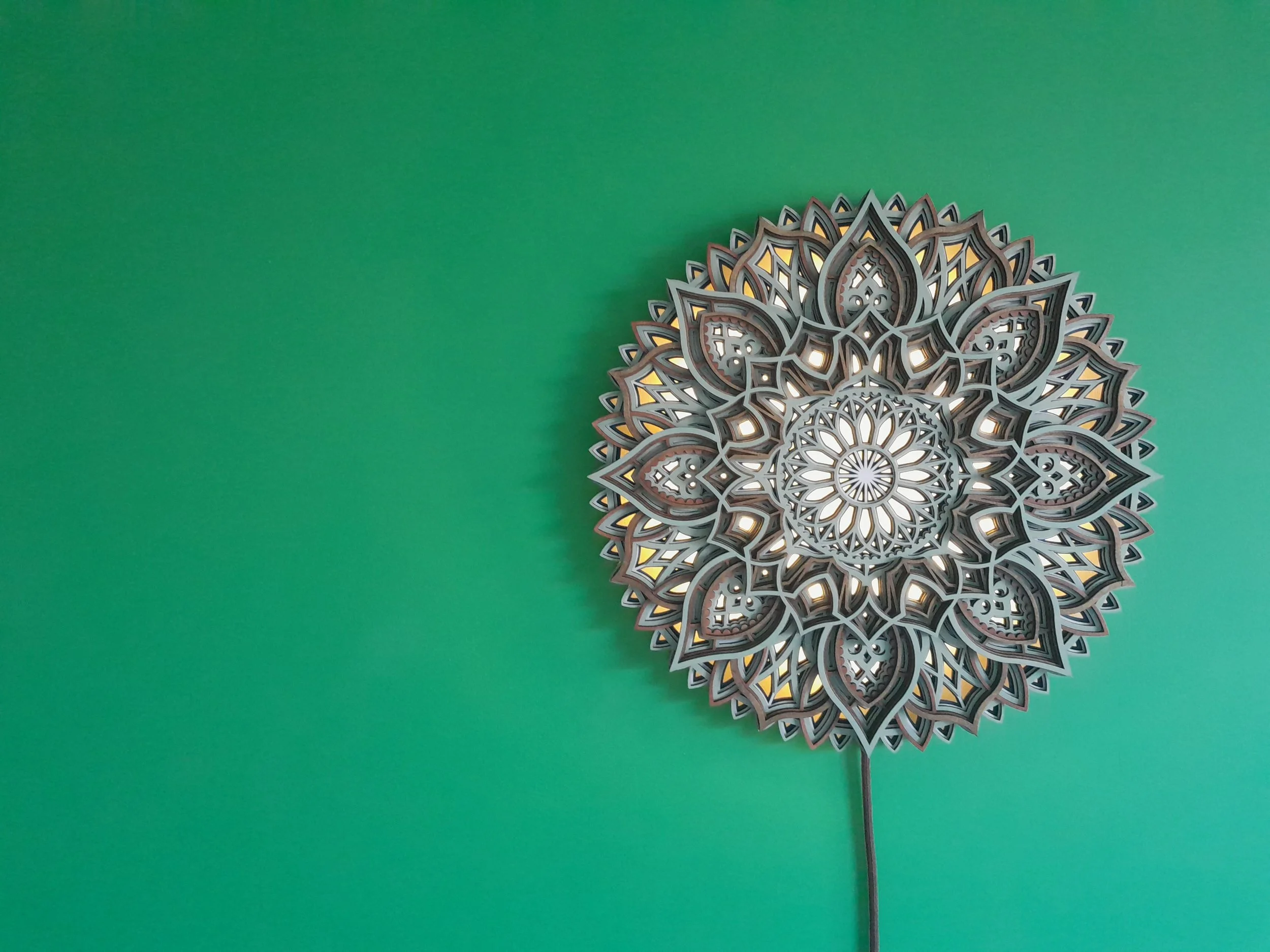 Intricate mandala design on green wall