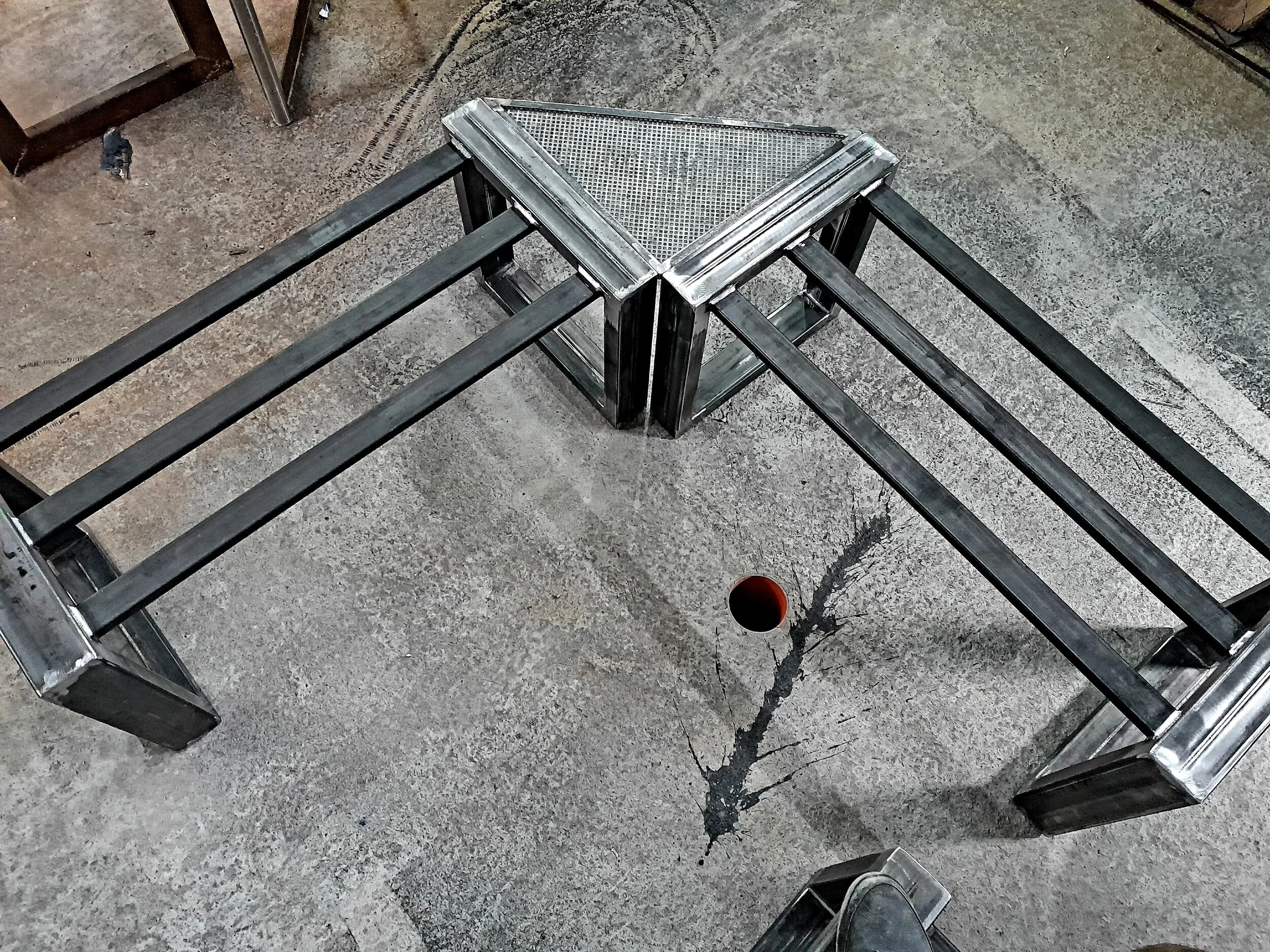 Metal frame structure with triangular top on concrete floor