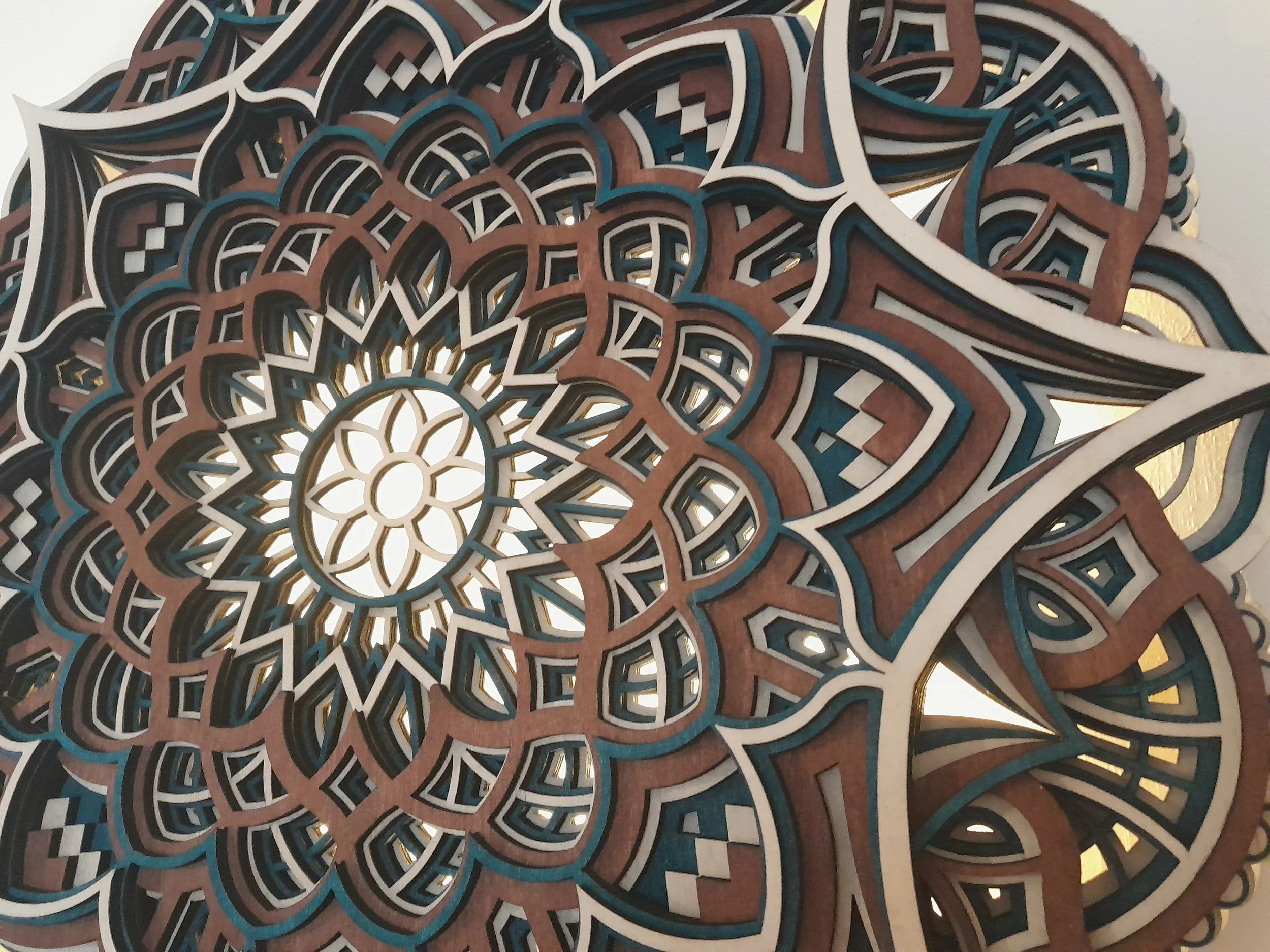 Intricate wooden geometric mandala with layered patterns and cutouts.