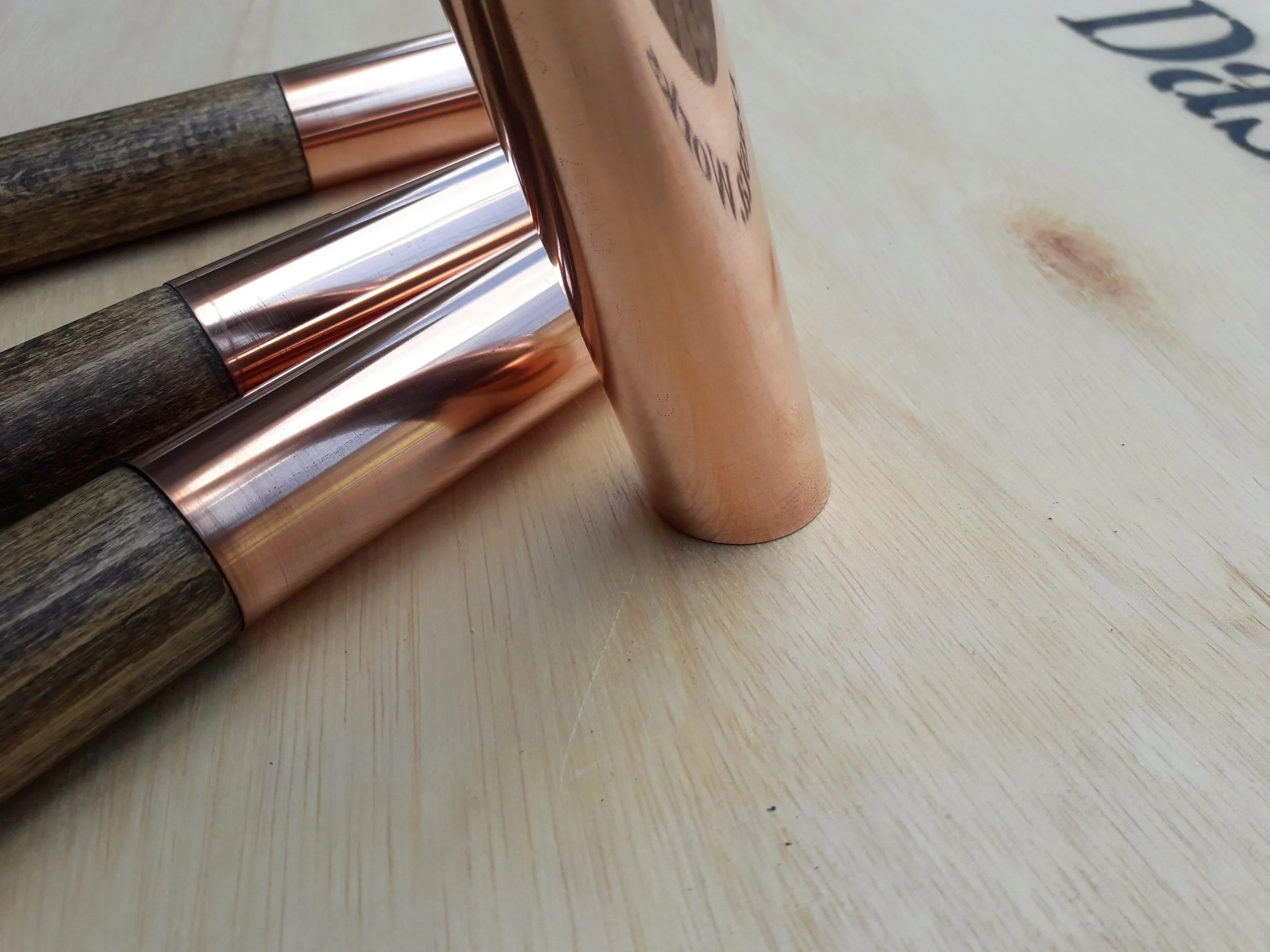 Copper-lined wooden handles on a wooden surface