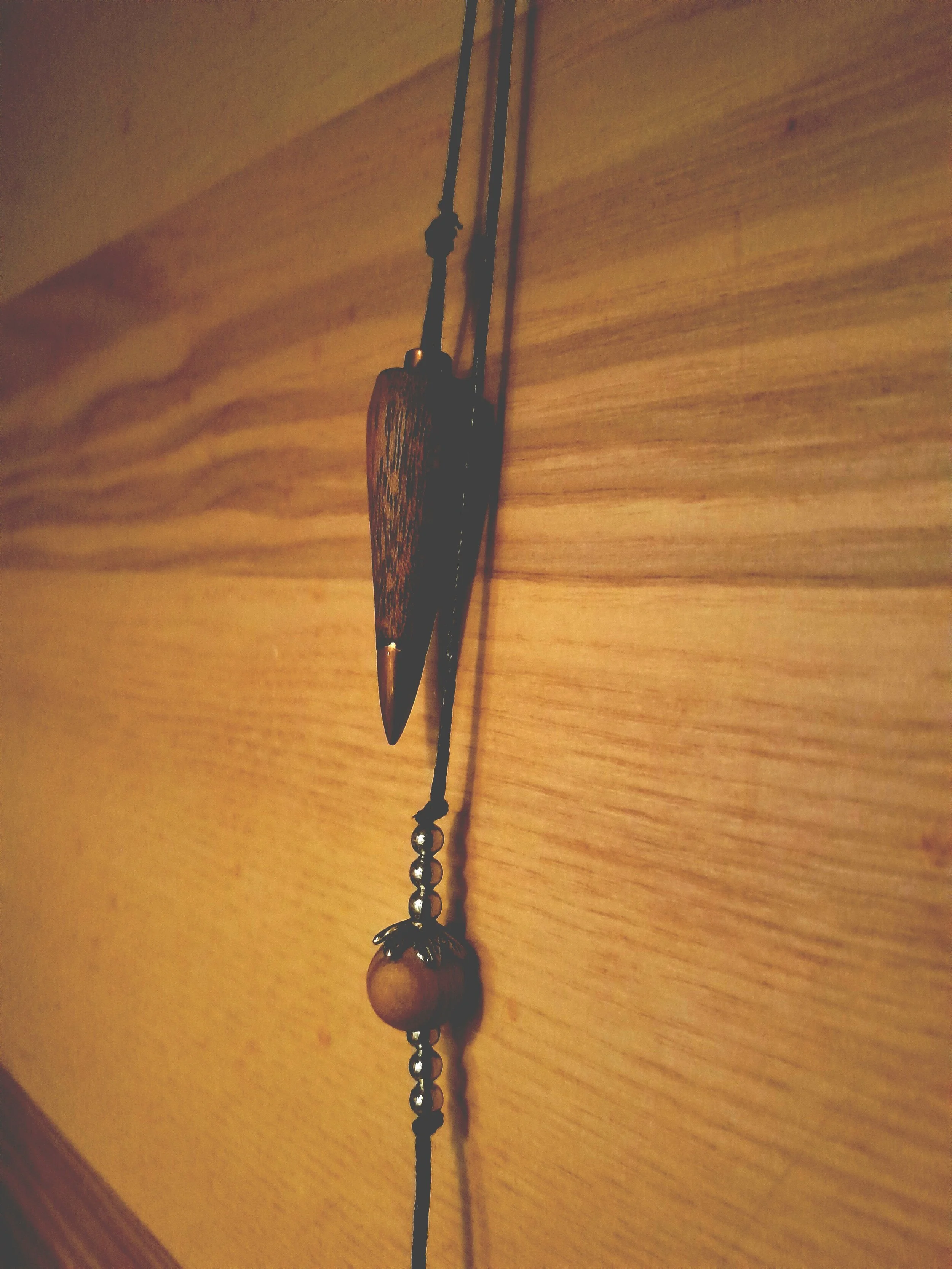 Wooden pendant necklace on a wooden wall