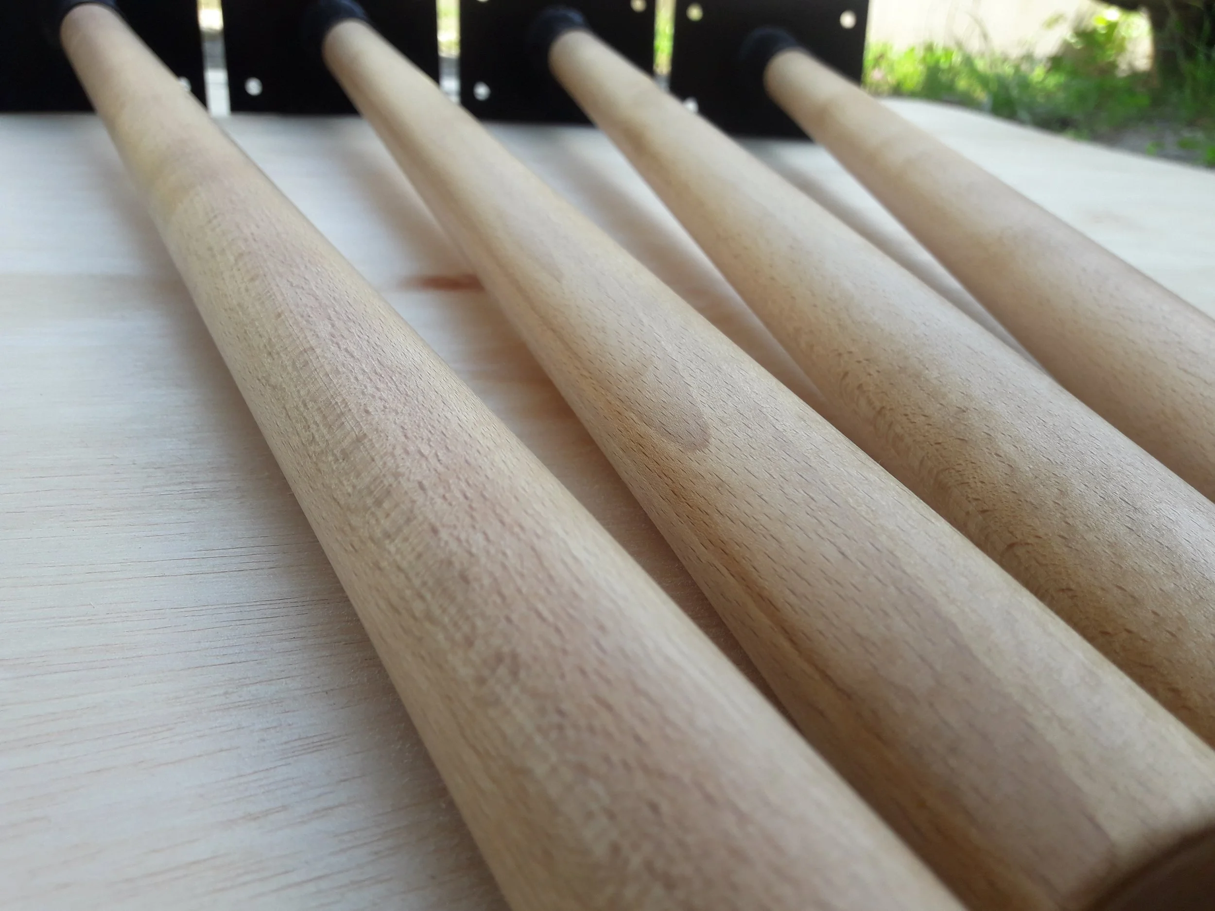Close-up of four wooden handle mallets on a wooden surface with black bases.