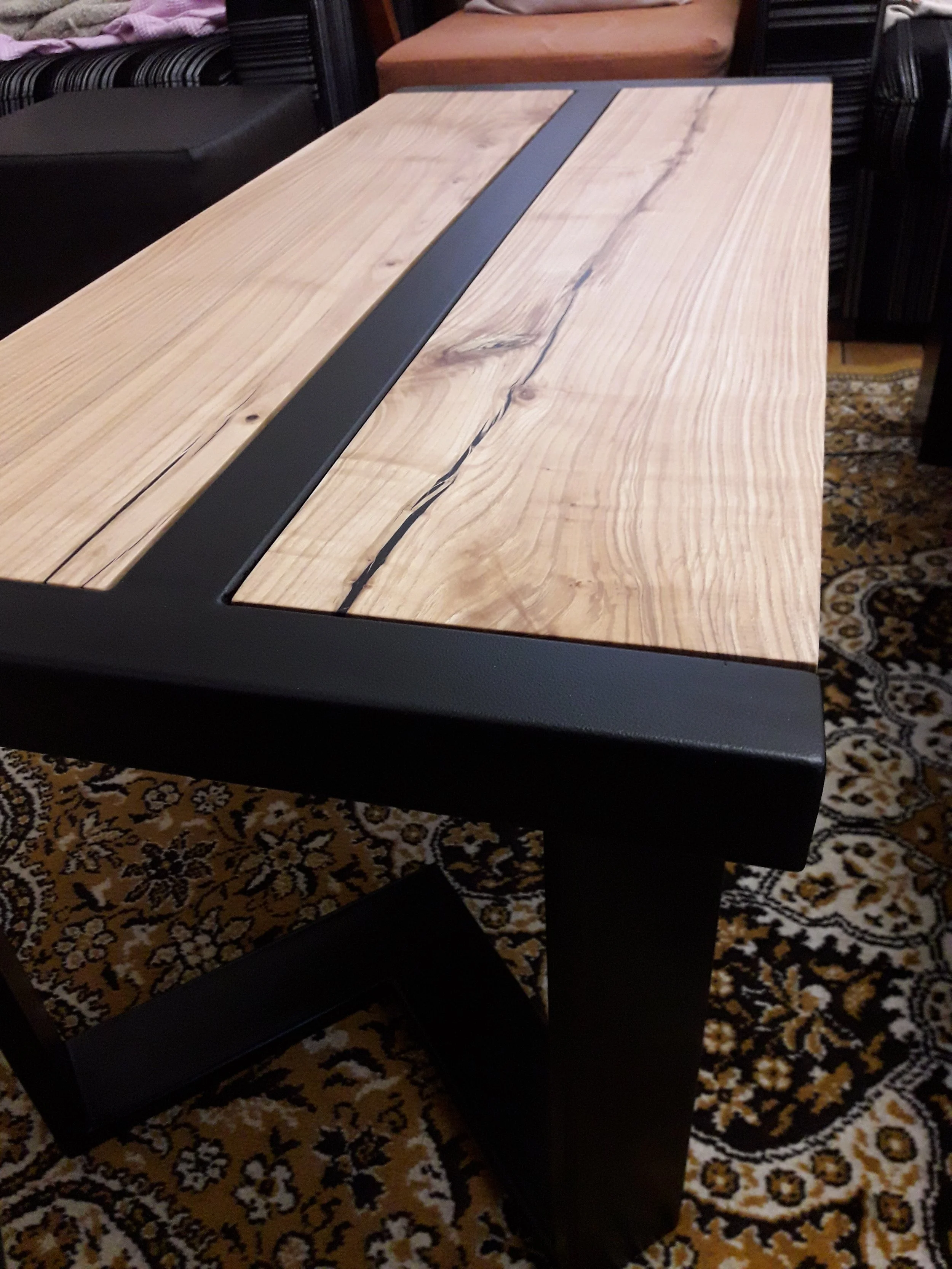 Modern wood and metal table on patterned carpet