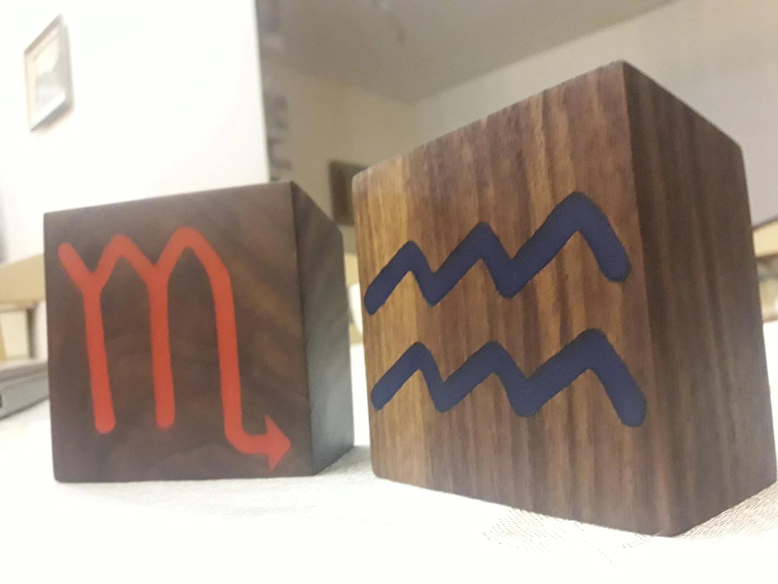 Wooden cubes with Scorpio and Aquarius zodiac symbols