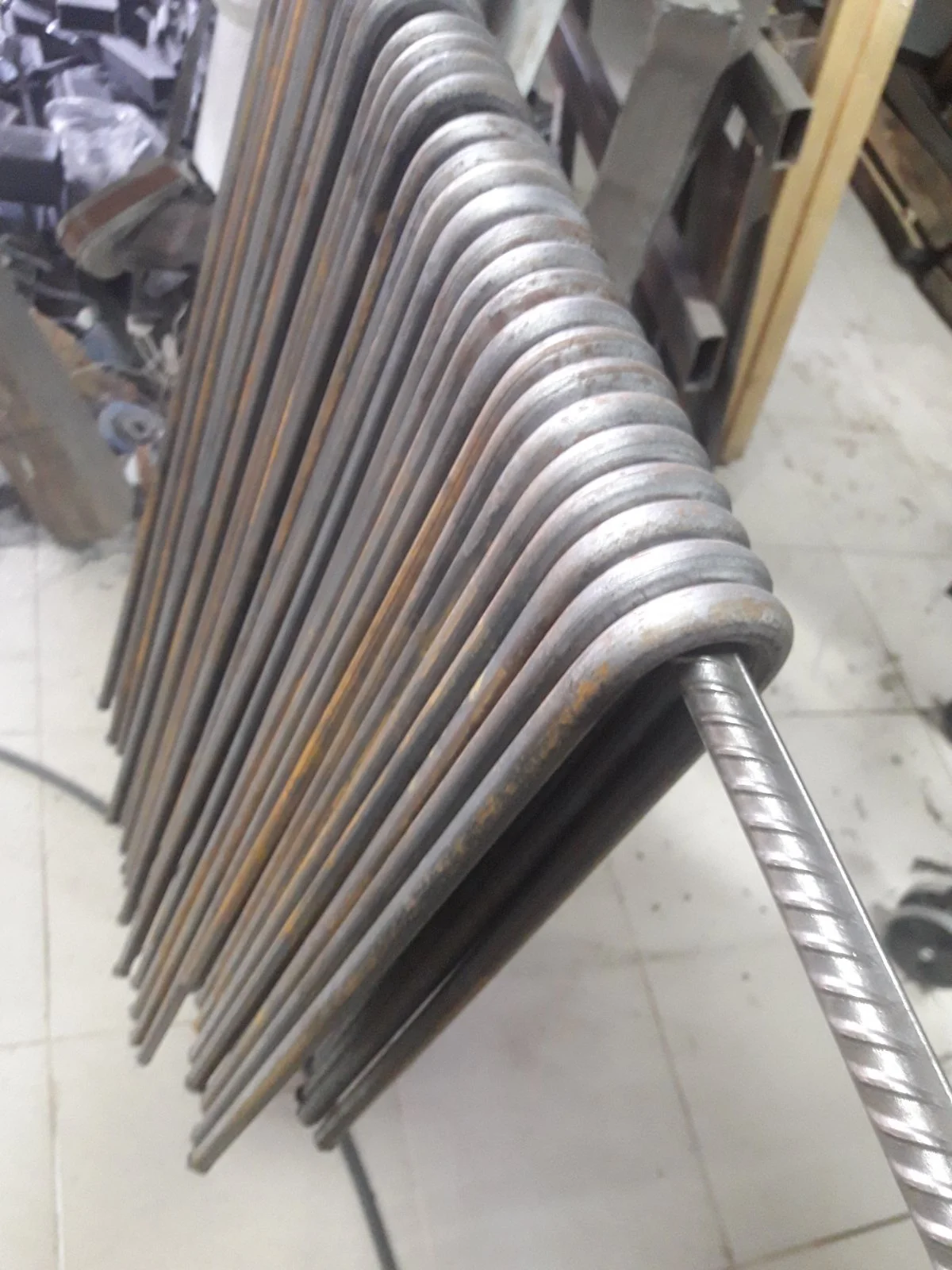 Stack of bent metal rods in a workshop
