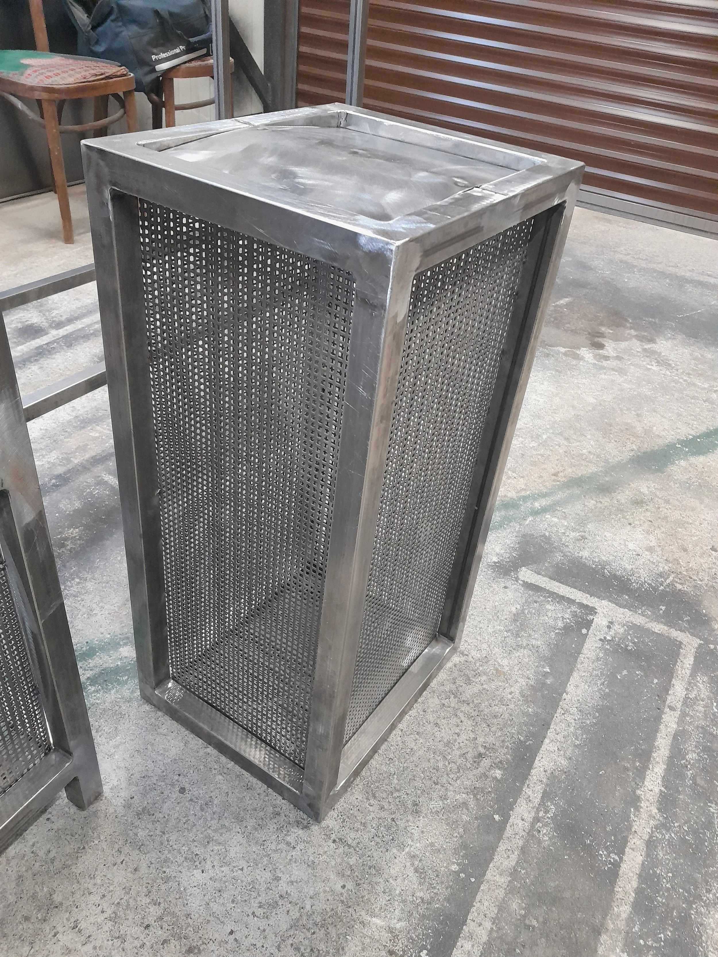 Metal mesh bin or container on concrete floor