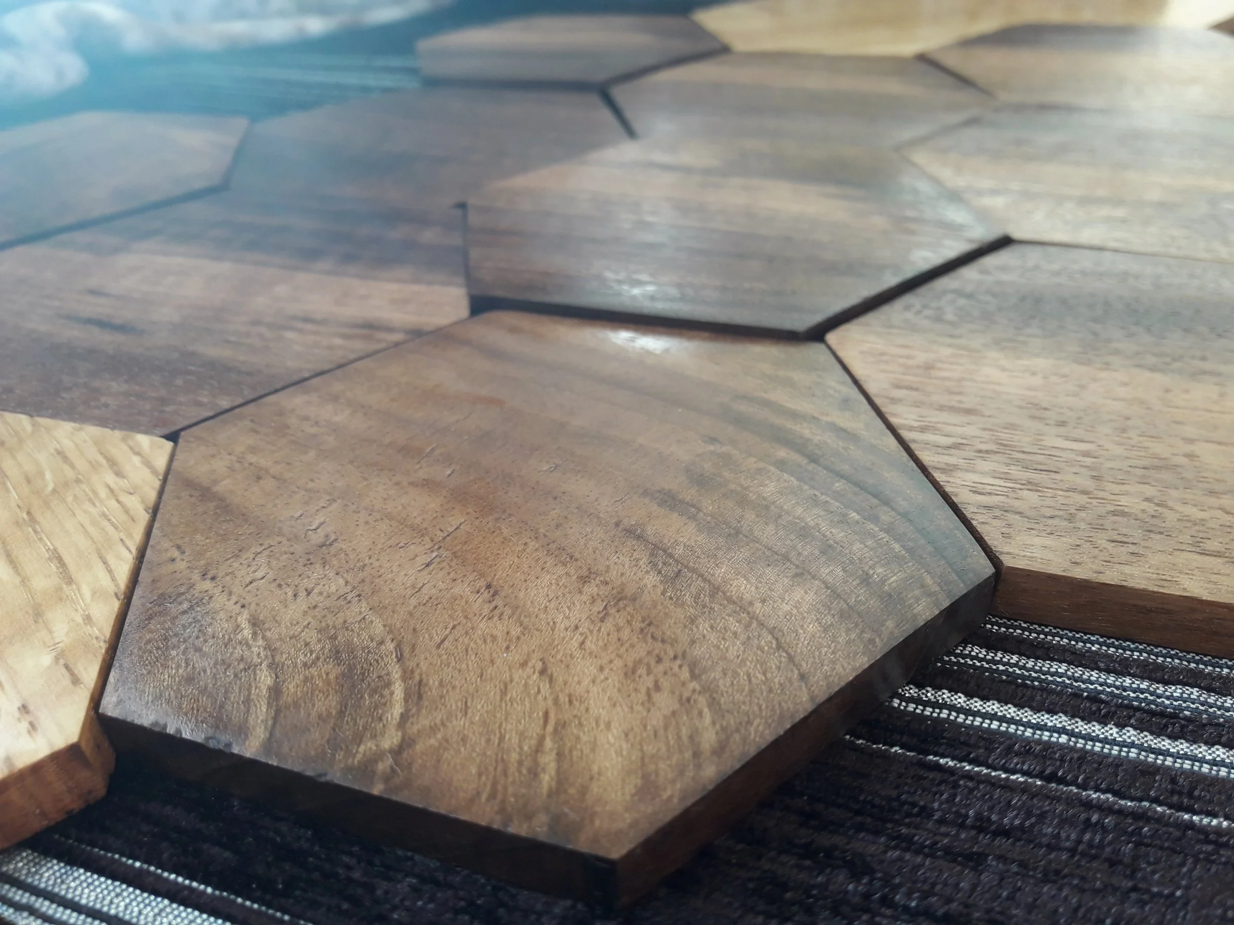 Close-up of interlocking wooden hexagonal tiles on a surface.