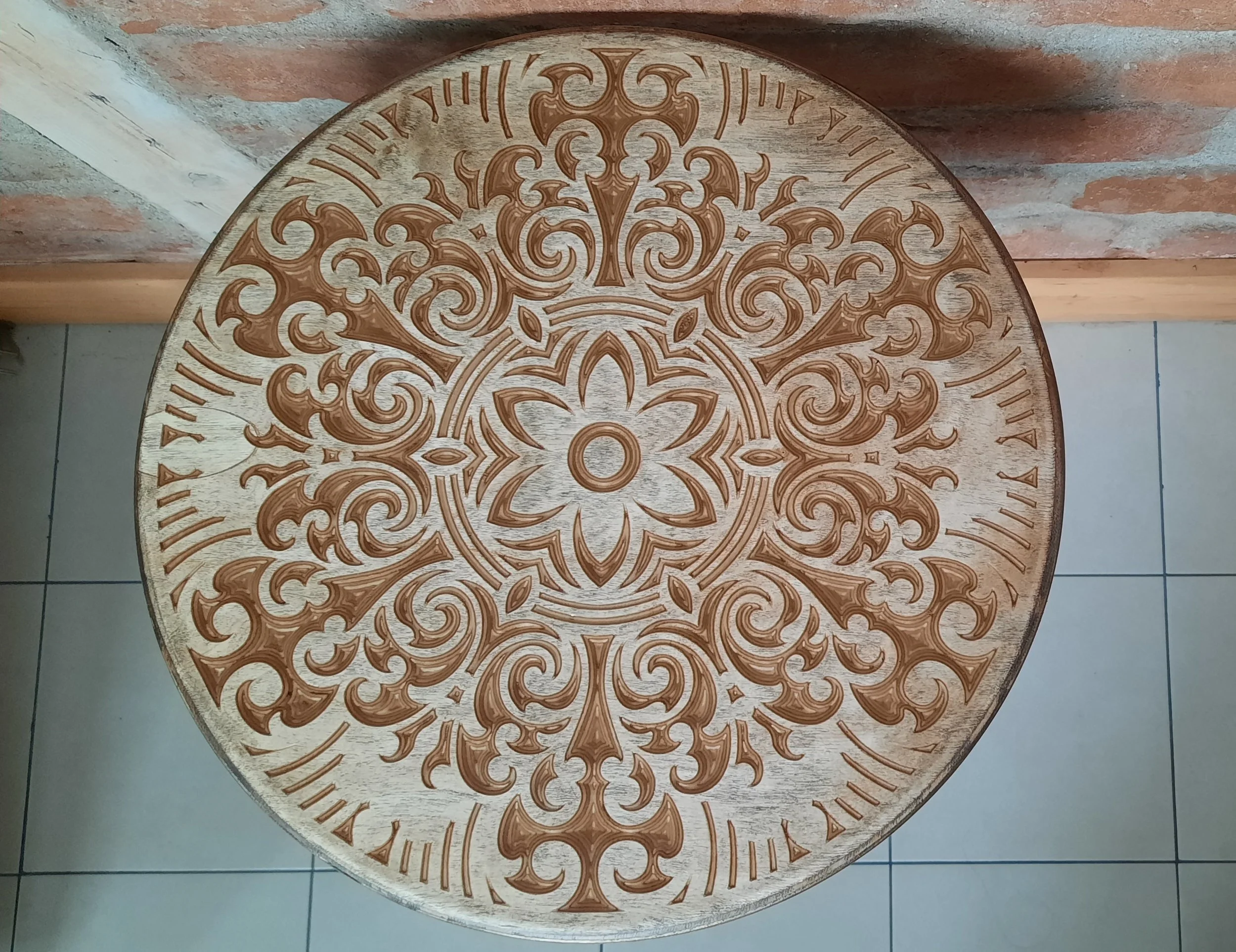 Round wooden table with intricate carved floral patterns