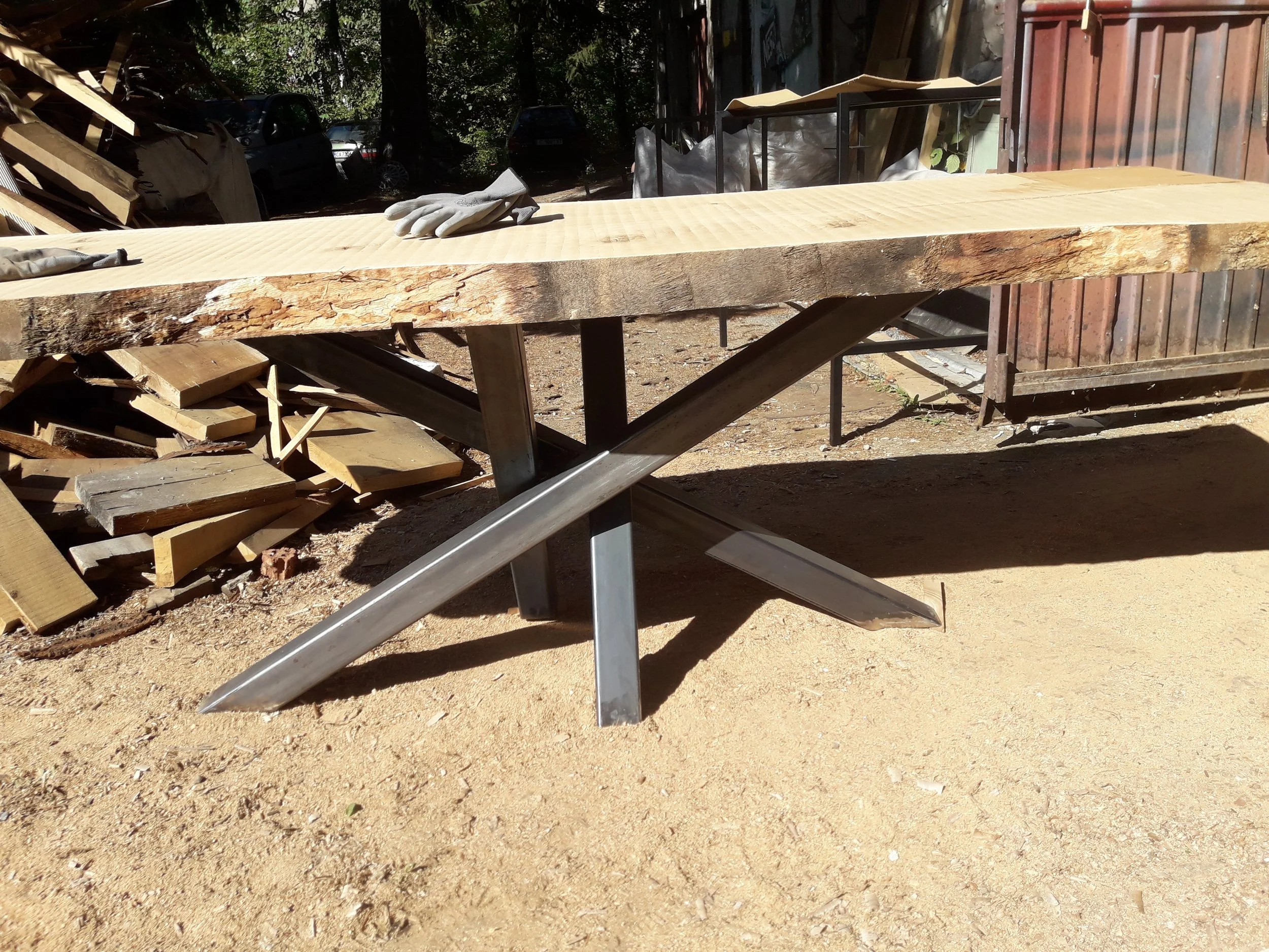 Wooden table with metal cross legs in outdoor setting