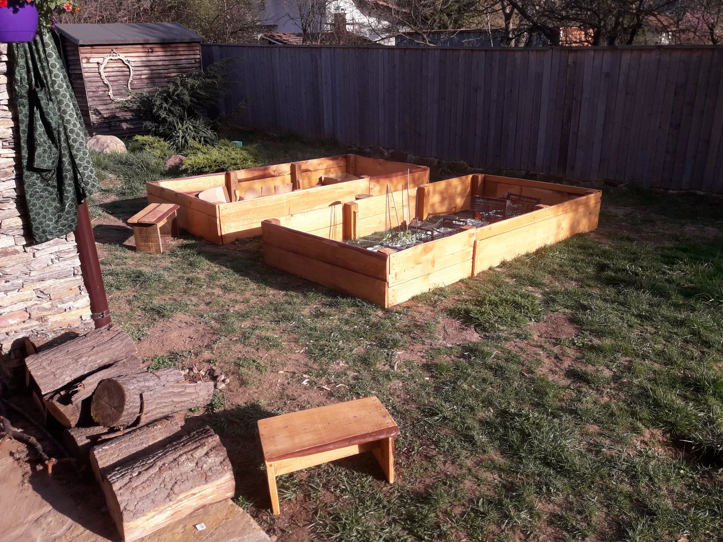 Backyard with raised garden beds and firewood