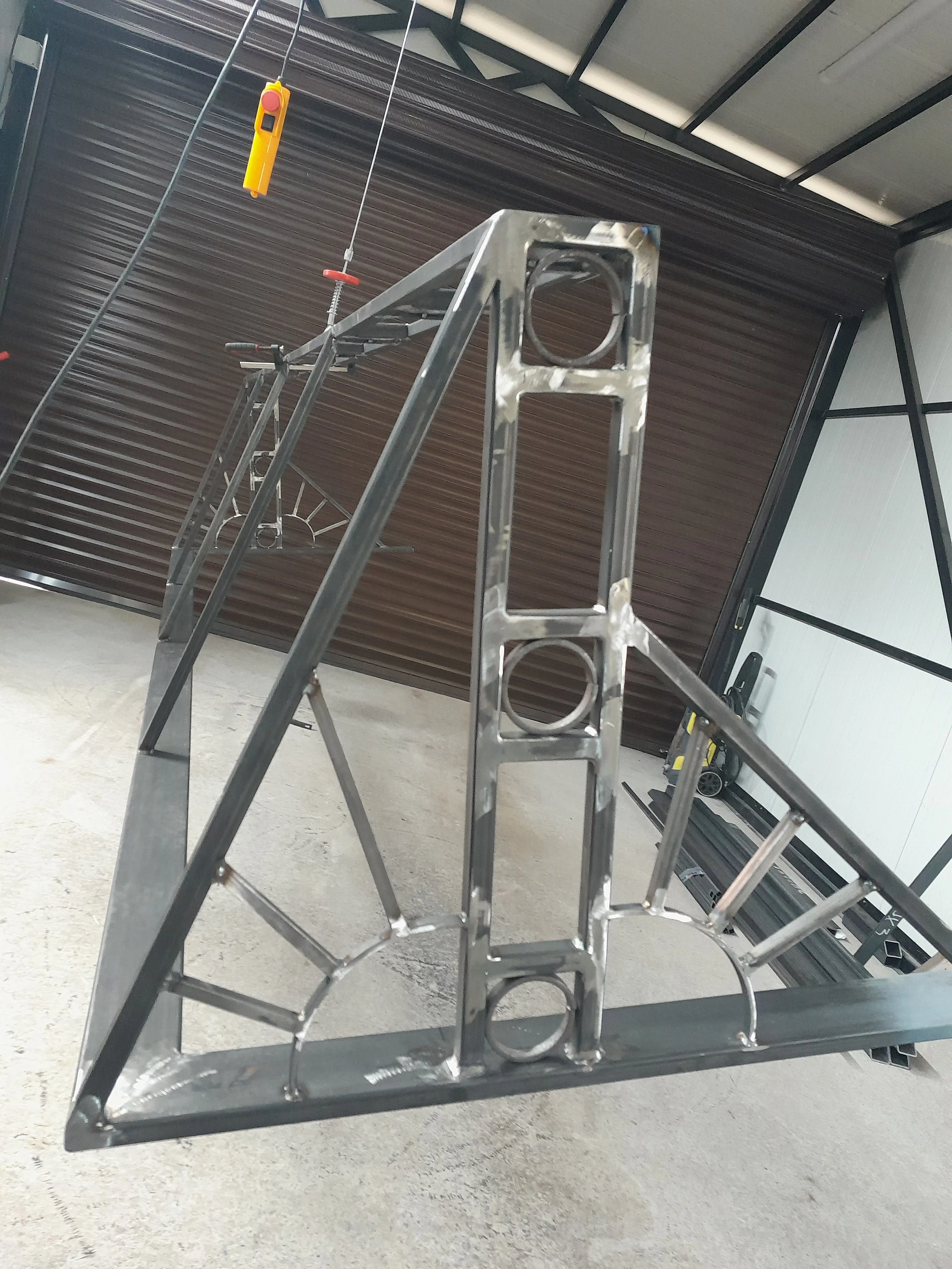 Metal frame construction inside a workshop with a hoist.