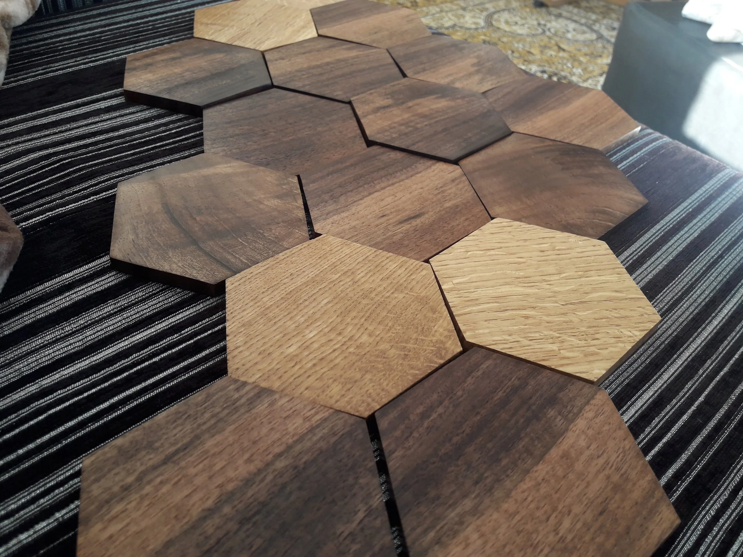 Wooden hexagon tiles arranged on a striped fabric surface