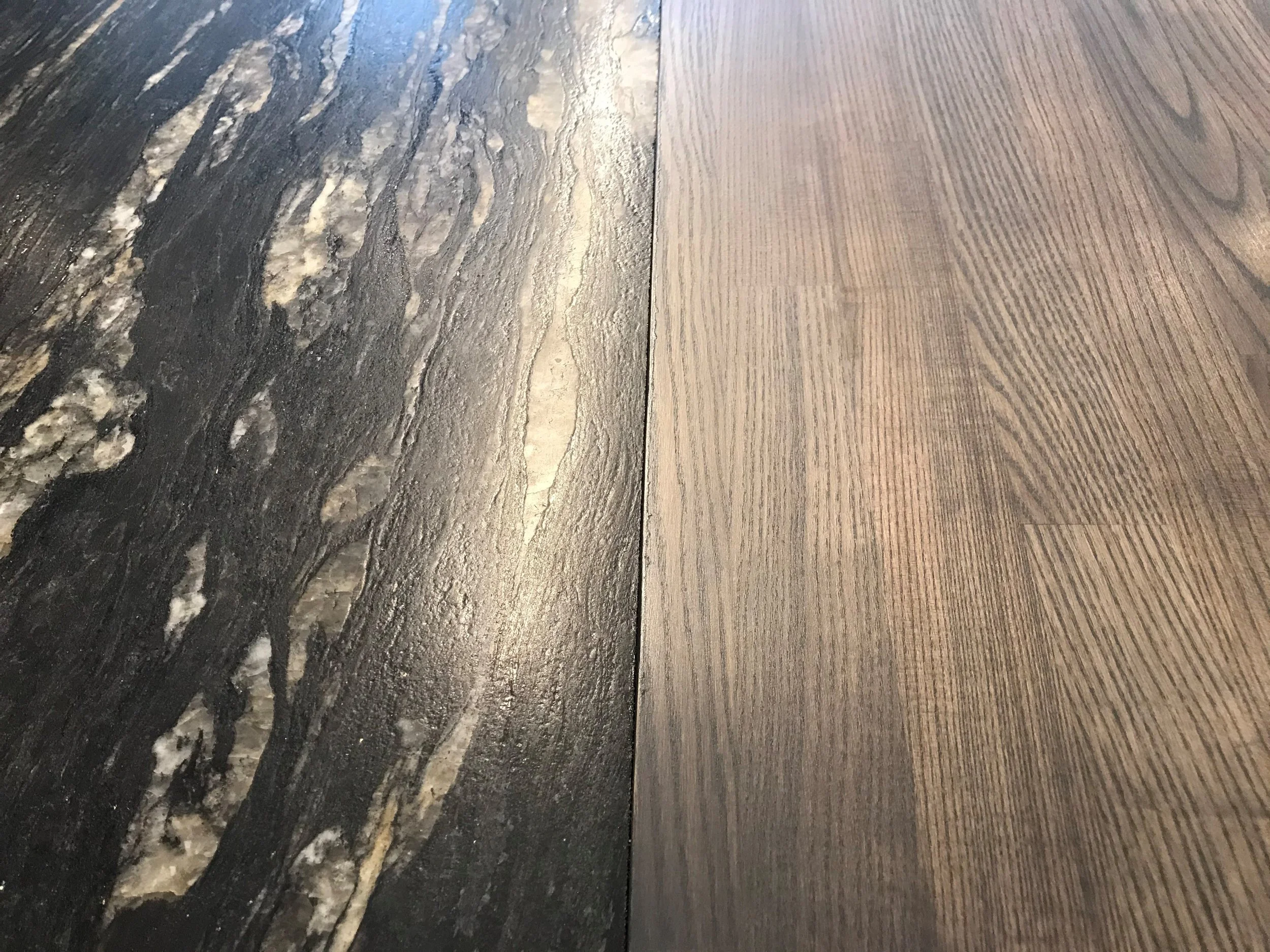 Close-up of two different wooden surfaces, one dark with a textured finish, the other lighter with a smooth grain pattern.