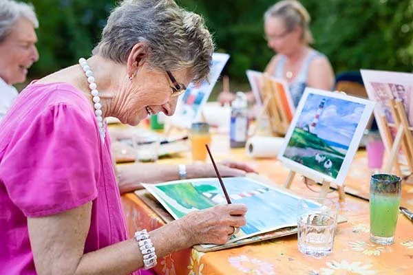 Senior woman participating in a group painting class