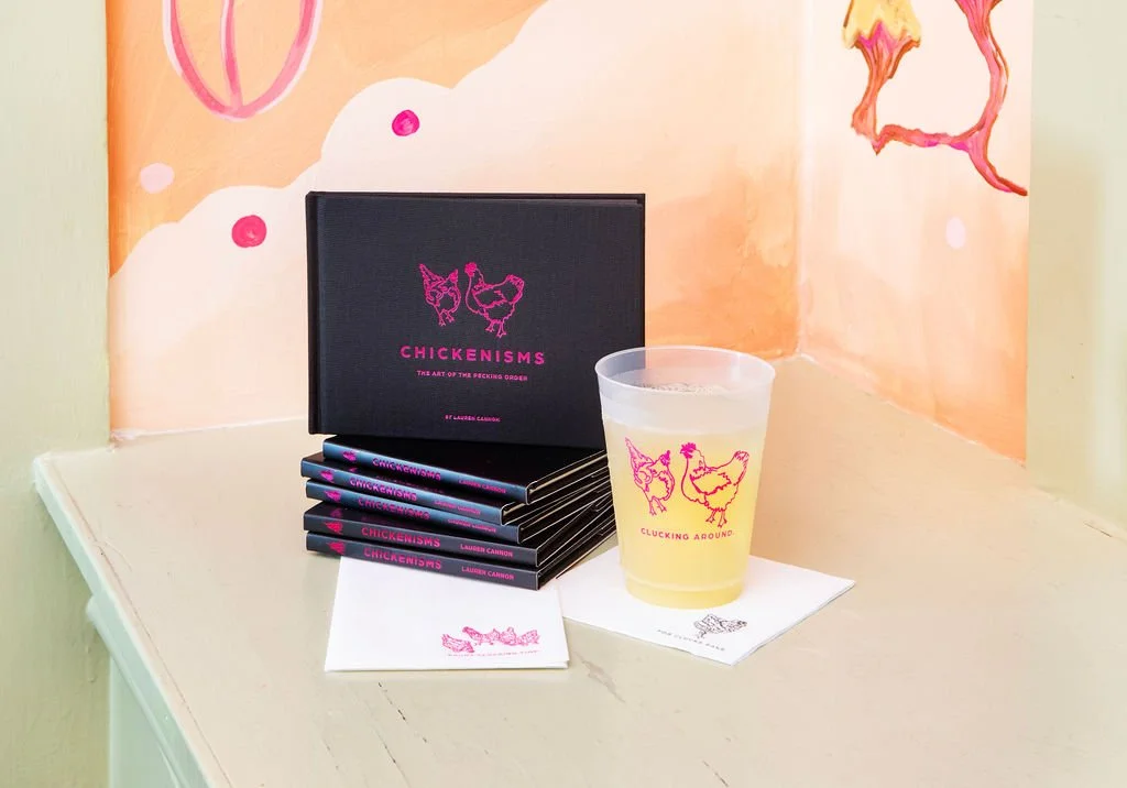 Chickenisms art book by Lauren Cannon displayed on a bold, colorful background with playful flat-lay styling