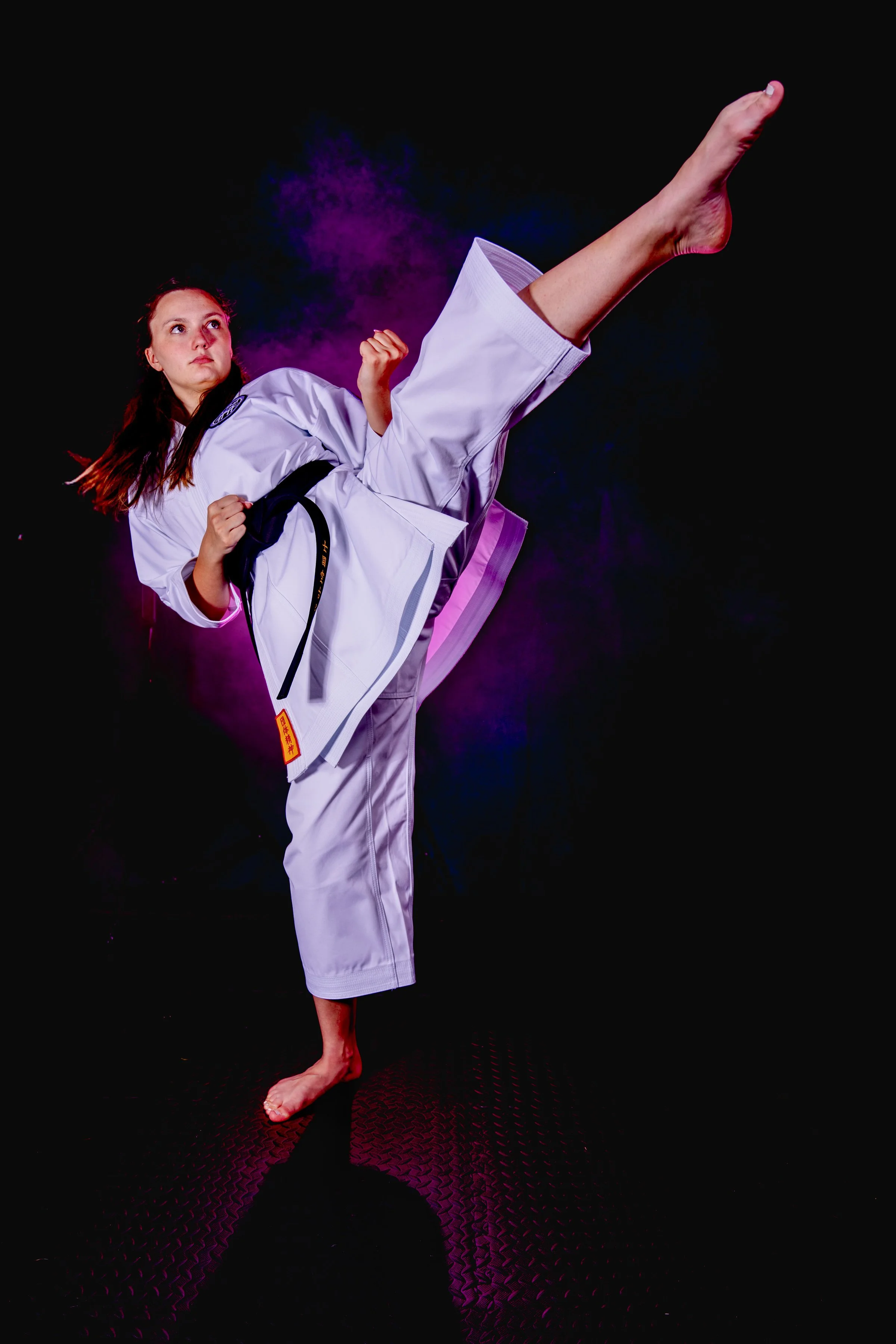 Karate athlete portrait by New Hampshire sports photographer with dramatic lighting and high kick