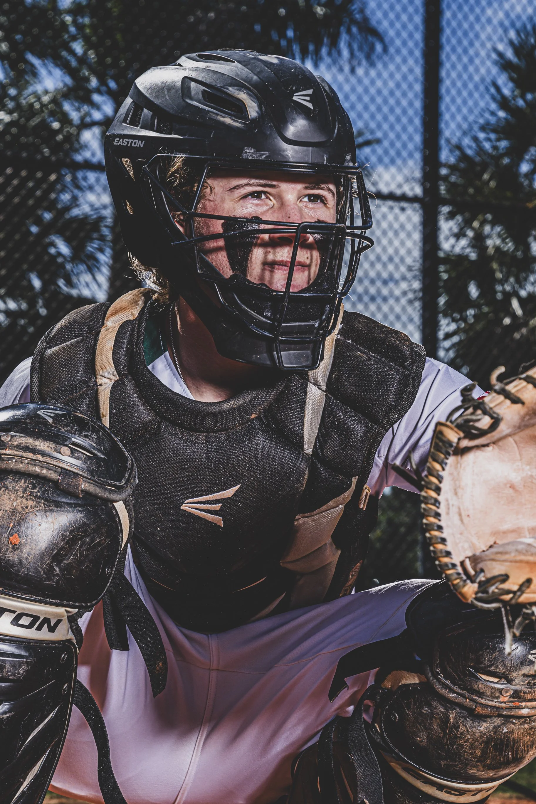 Baseball catcher portrait by New Hampshire sports photographer with dramatic lighting and intense expression