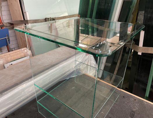 Mueble velador de vidrio con tapa biselada.