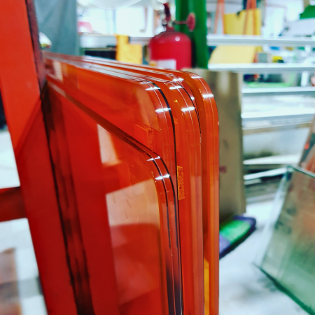 Pulido brillante de radios sobre vidrio laminado color naranja de 8 mm.