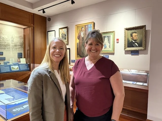 Darley Newman with Dr. Susannah Urul inside the Lincolniana collection at Mississippi State University, discussing the legacy of Abraham Lincoln amid historic portraits and artifacts.