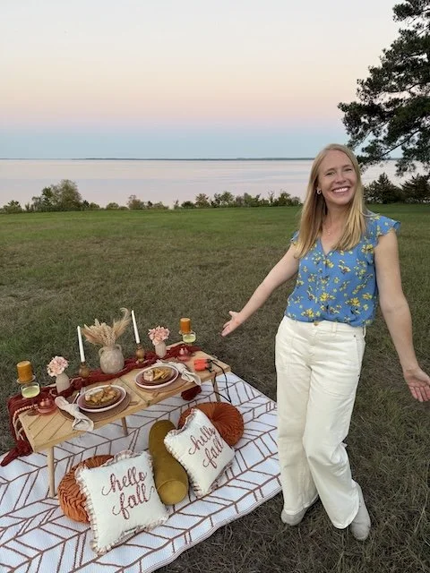 Darley Newman welcoming sunset at the Reservoir Overlook in Ridgeland along the Natchez Trace—an inviting picnic, soft skies, and Mississippi beauty stretching to the horizon.