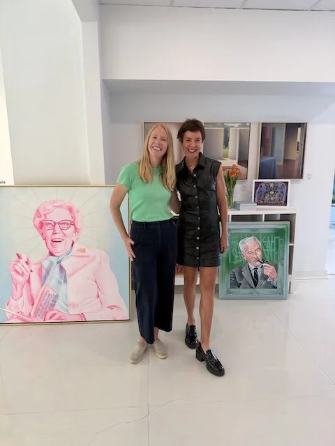 Darley Newman with Marcy Fischer Nessel at Fischer Galleries, standing beside portraits of Eudora Welty and William Faulkner by artist Rosie Ferguson Gathings.