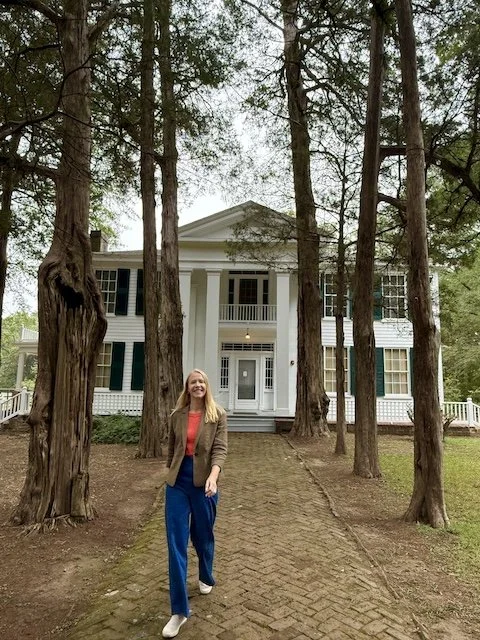 Darley Newman walks the bricked path to Rowan Oak, the historic Oxford home of William Faulkner, framed by the tall cedar trees that line the entrance.