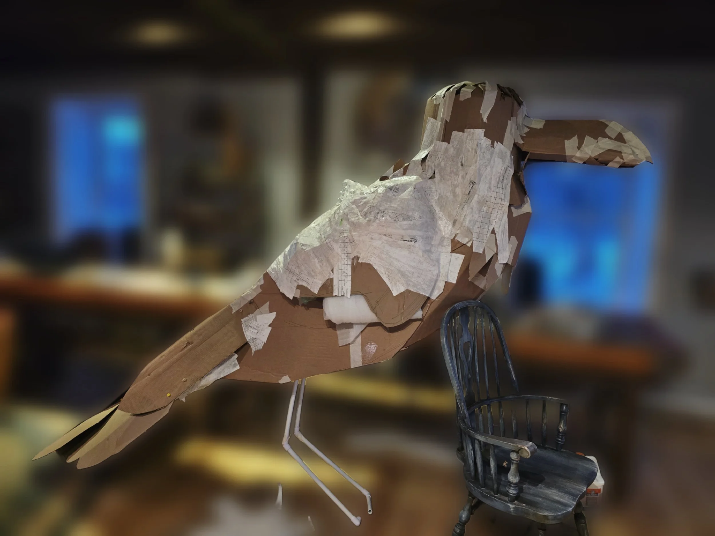 A 7 feet tall cardboard raven is in the process of being made.