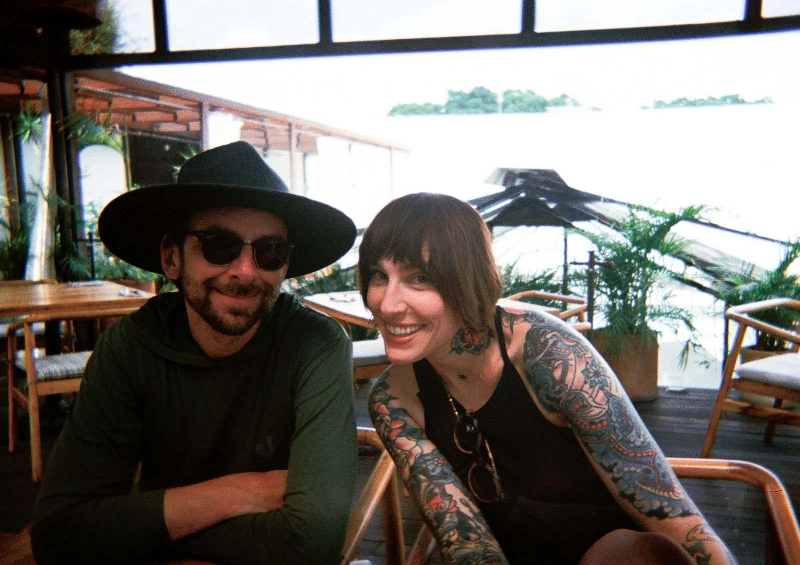 Close-up of a man with dark hair and a beard, looking to the side, in front of a blurred background.