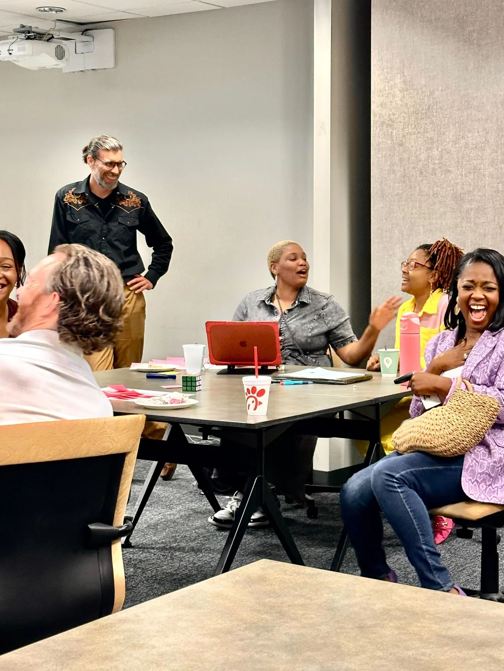 Attendees seated around tables in conversation at a Helen's Project gathering
