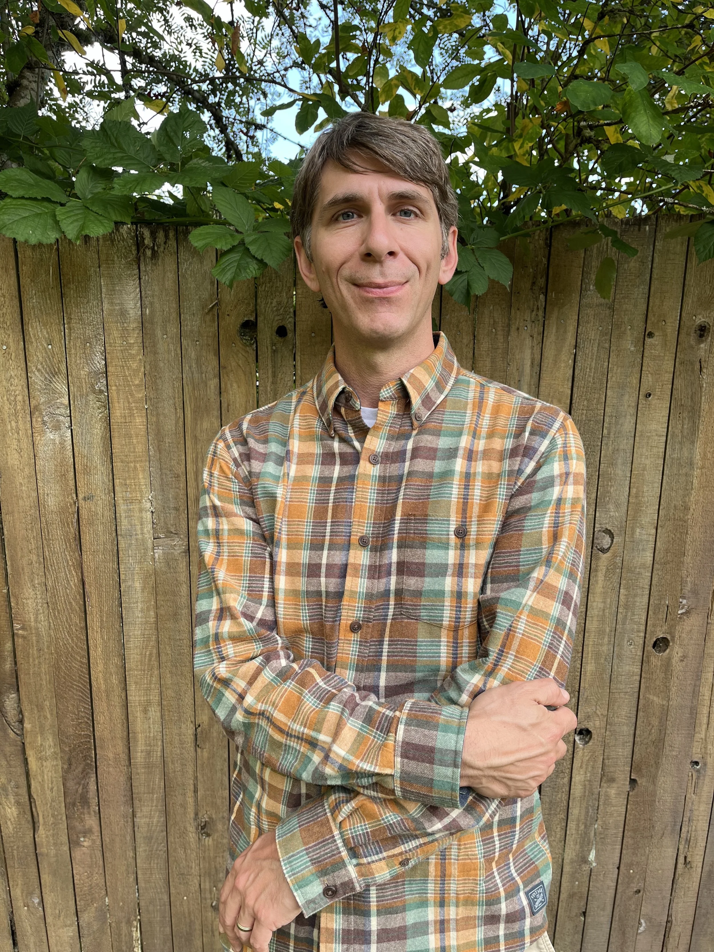 Kip Kaiser standing near a wooden fence