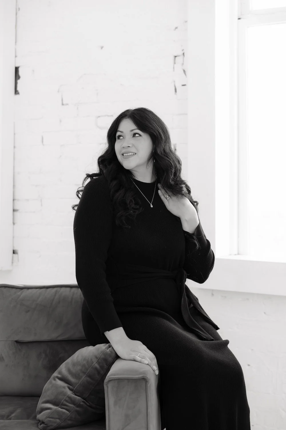 Photo of Gabrielle sitting sideways, smiling and looking over her shoulder.