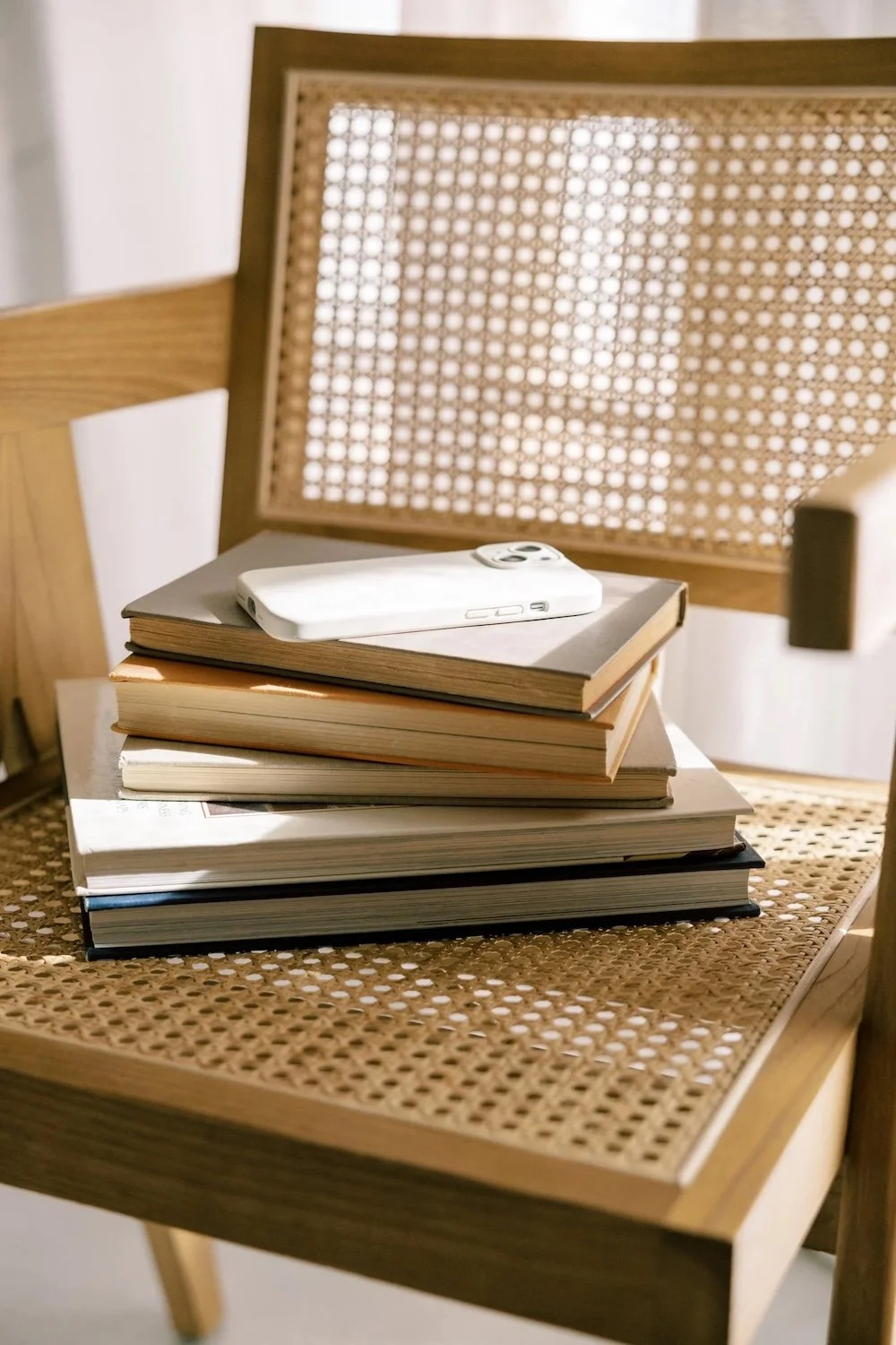 A pile of books stacked on a chair.