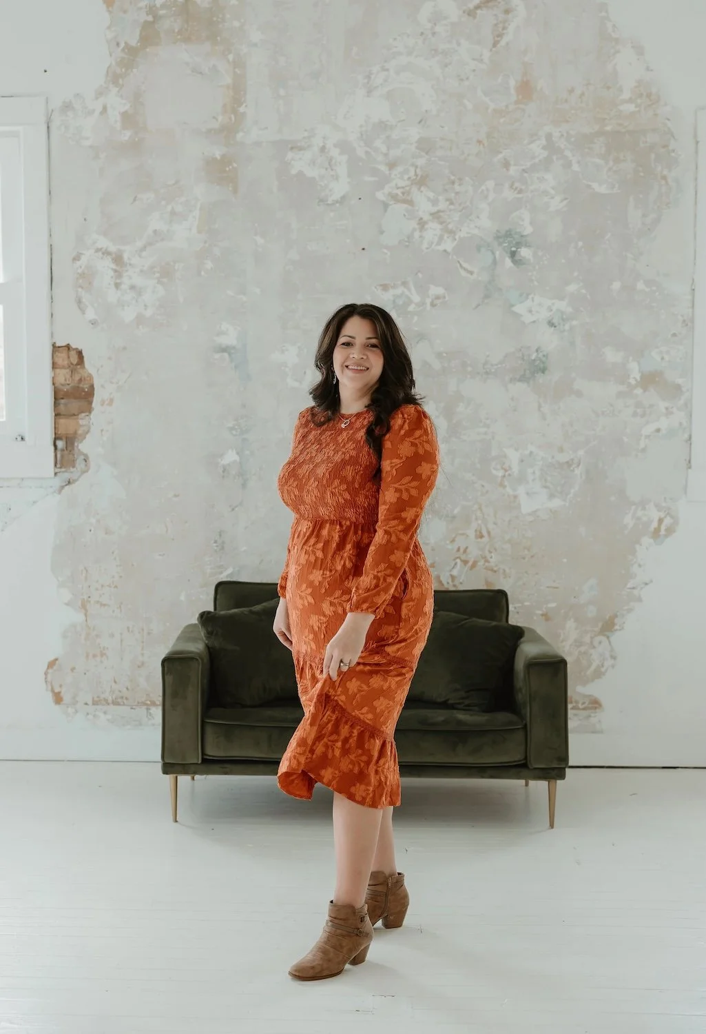 Photo of Gabrielle standing sideways, smiling and turning to face the frame.