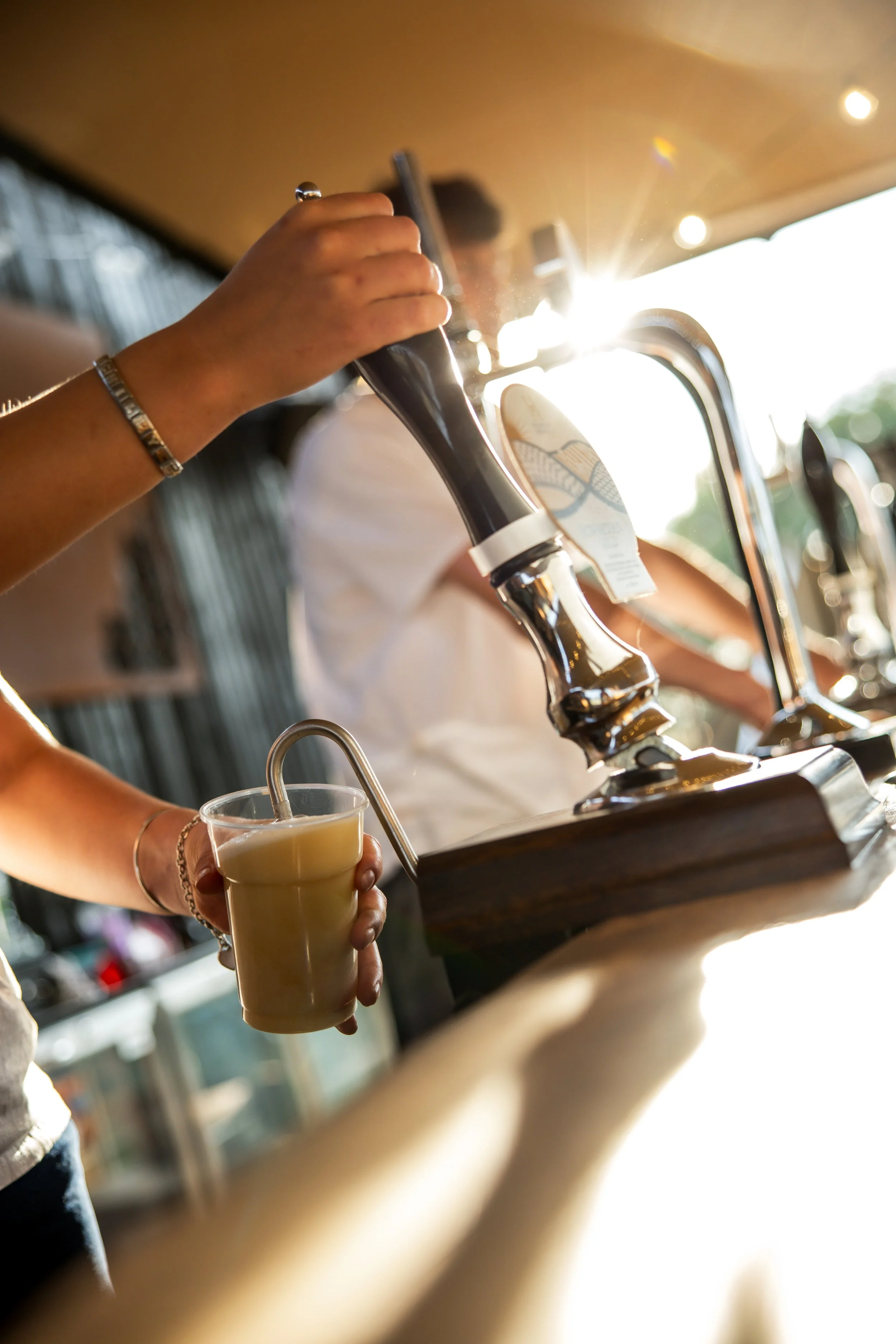 A person pouring a pint of beer.